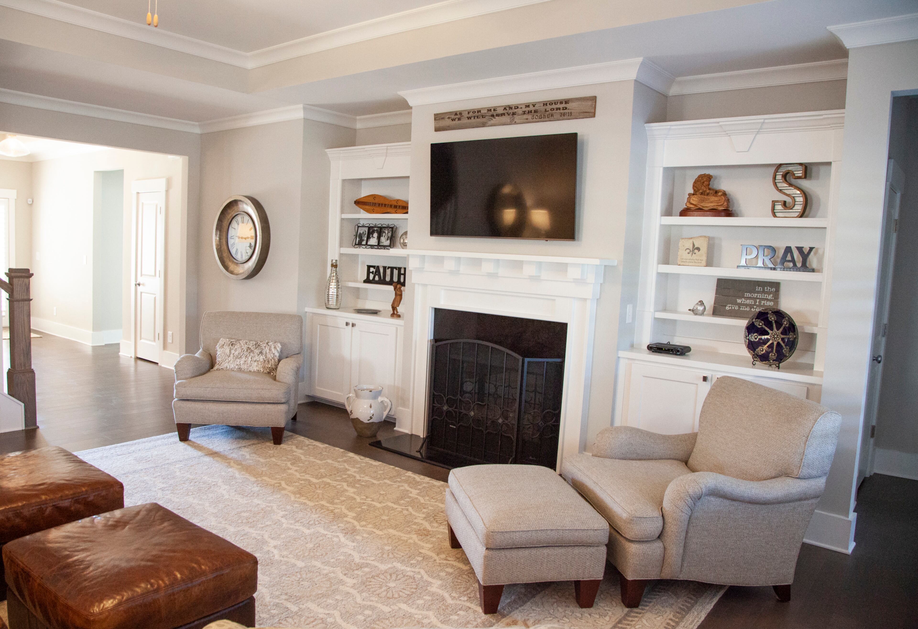 Built-ins surround the fireplace and television in the den, displaying important pieces to the Slaughters, like the carved lion and lamb from a trip to Israel. The chairs were reupholstered by The Bronze Monkey in Marietta.