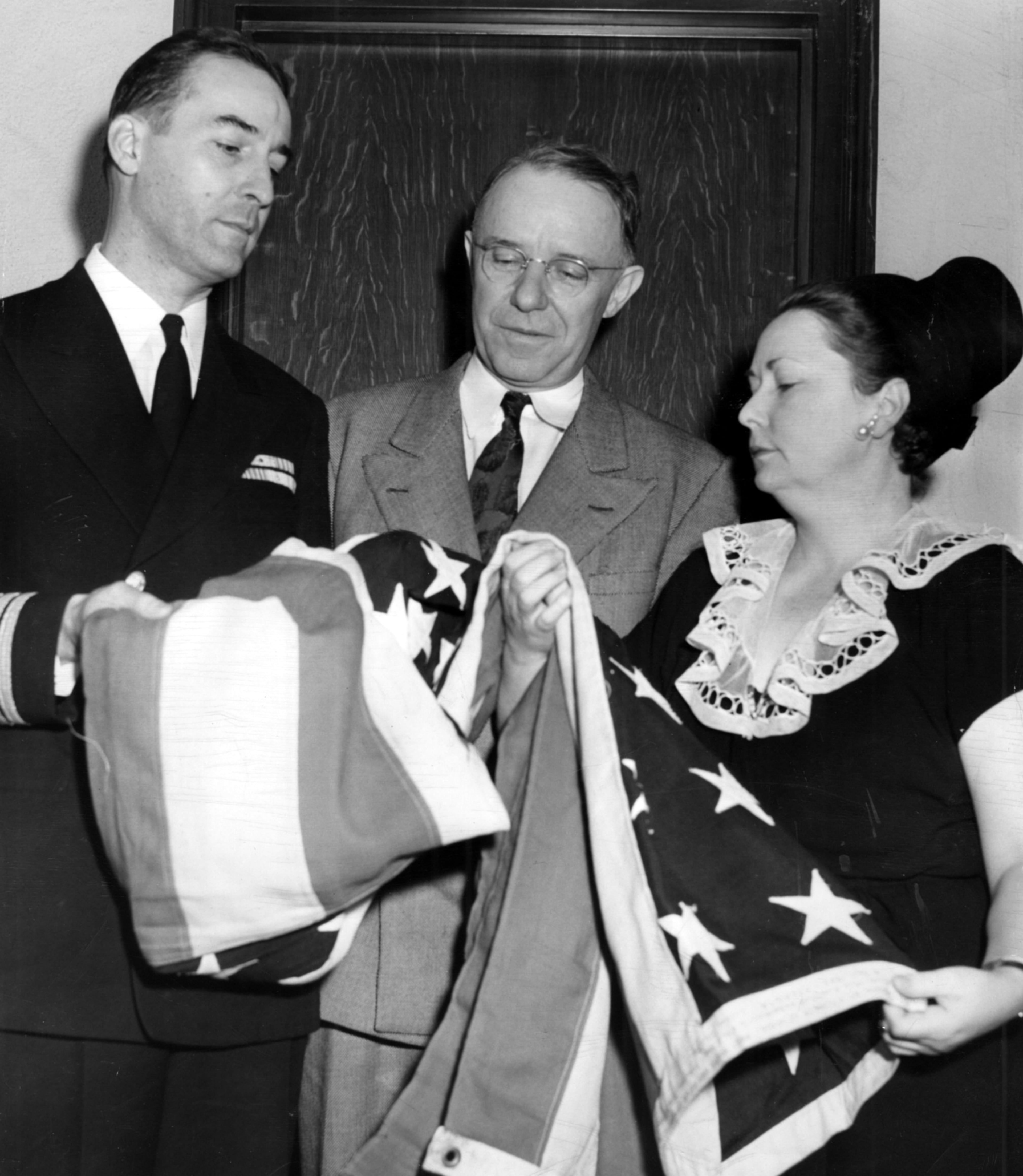 Years after the USS Atlanta sank at Guadalcanal, Captain Henry C. Davis presents the flag from the light cruiser to mayor William B. Hartsfield and Margaret Mitchell Marsh on Dec. 2, 1946.