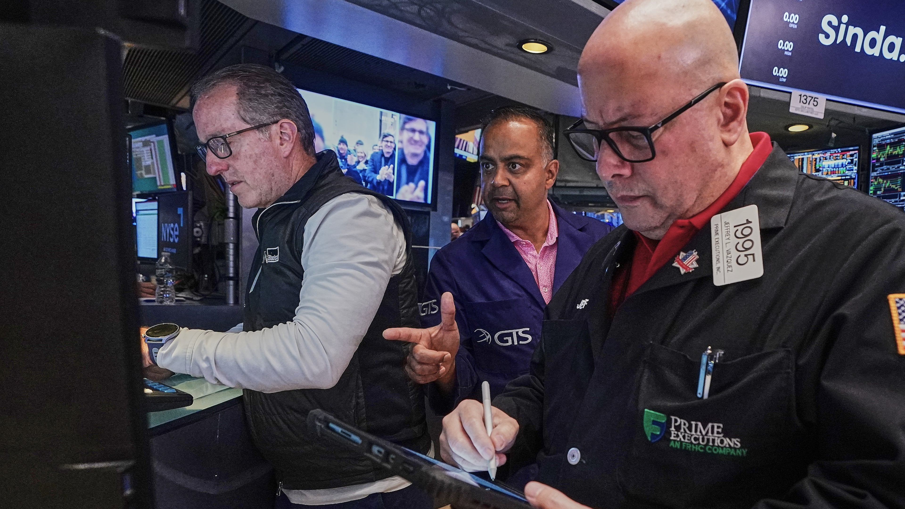 Specialist Glenn Carell, left, and Dilip Patel, center, work with trader Jeffrey Vazquez on the floor of the New York Stock Exchange, Friday, June 26, 2026. (AP Photo/Richard Drew)