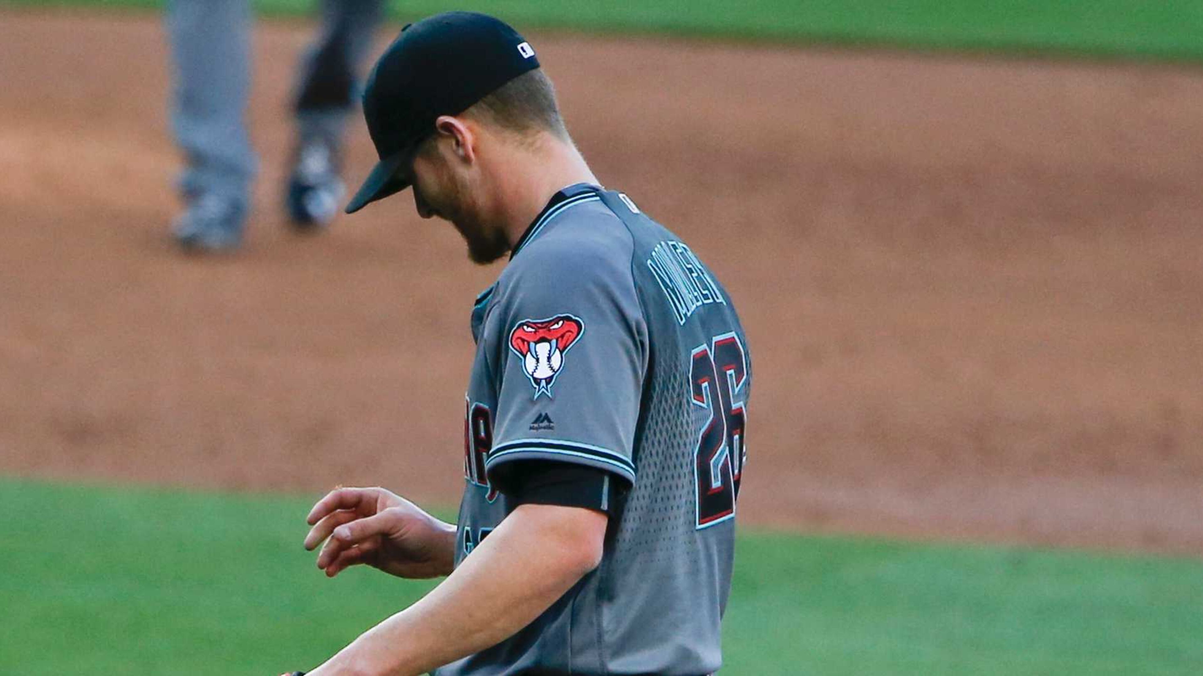 Diamondbacks pitcher Shelby Miller stares at his hand after banging it on the ground while following through on a pitch. (AP Photo/Lenny Ignelzi)