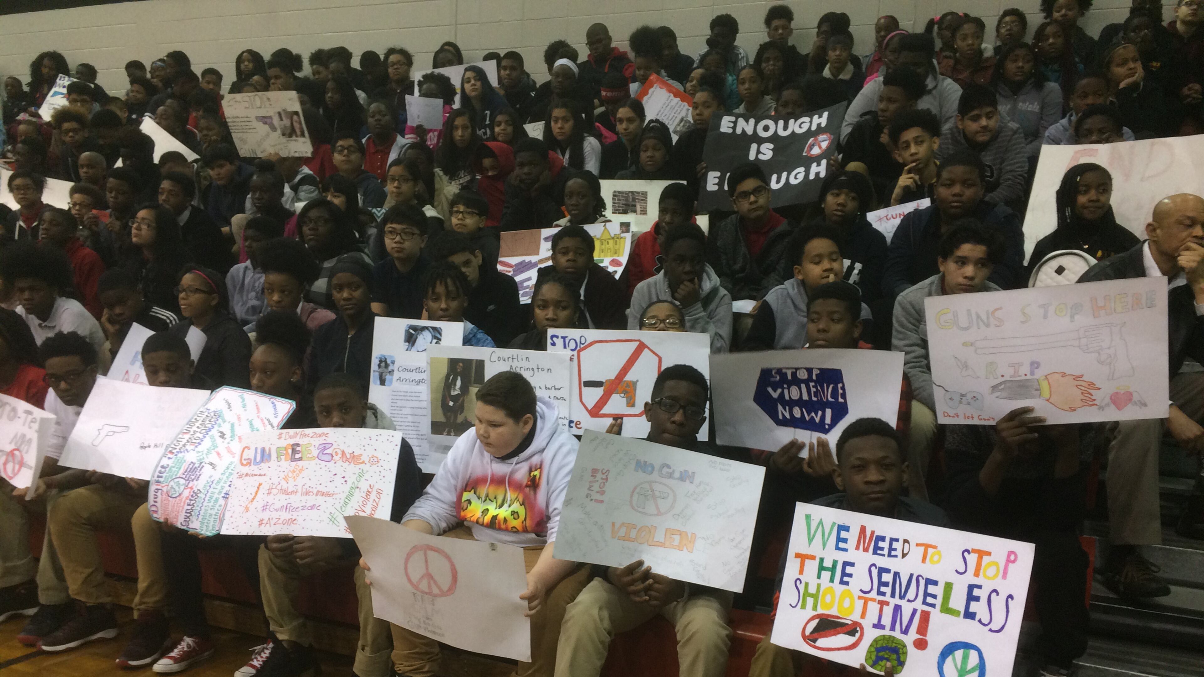 Students at Mundy’s Mill Middle School in Clayton County, some with anti-gun posters, gathered in the gym for a ceremony honoring slain Florida students and demanding action.