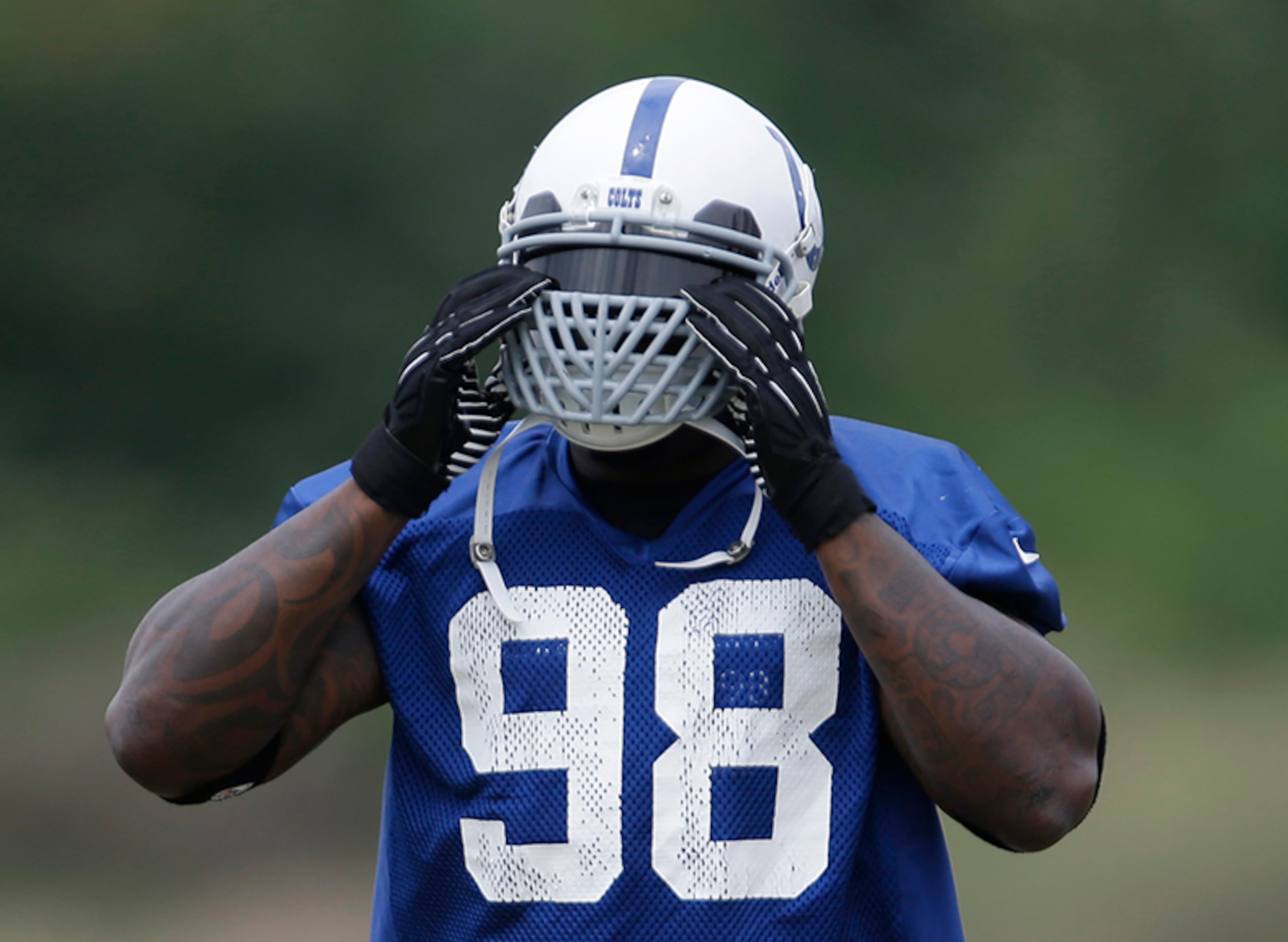 Indianapolis Colts outside linebacker Robert Mathis adjusted his facemask for training camp.