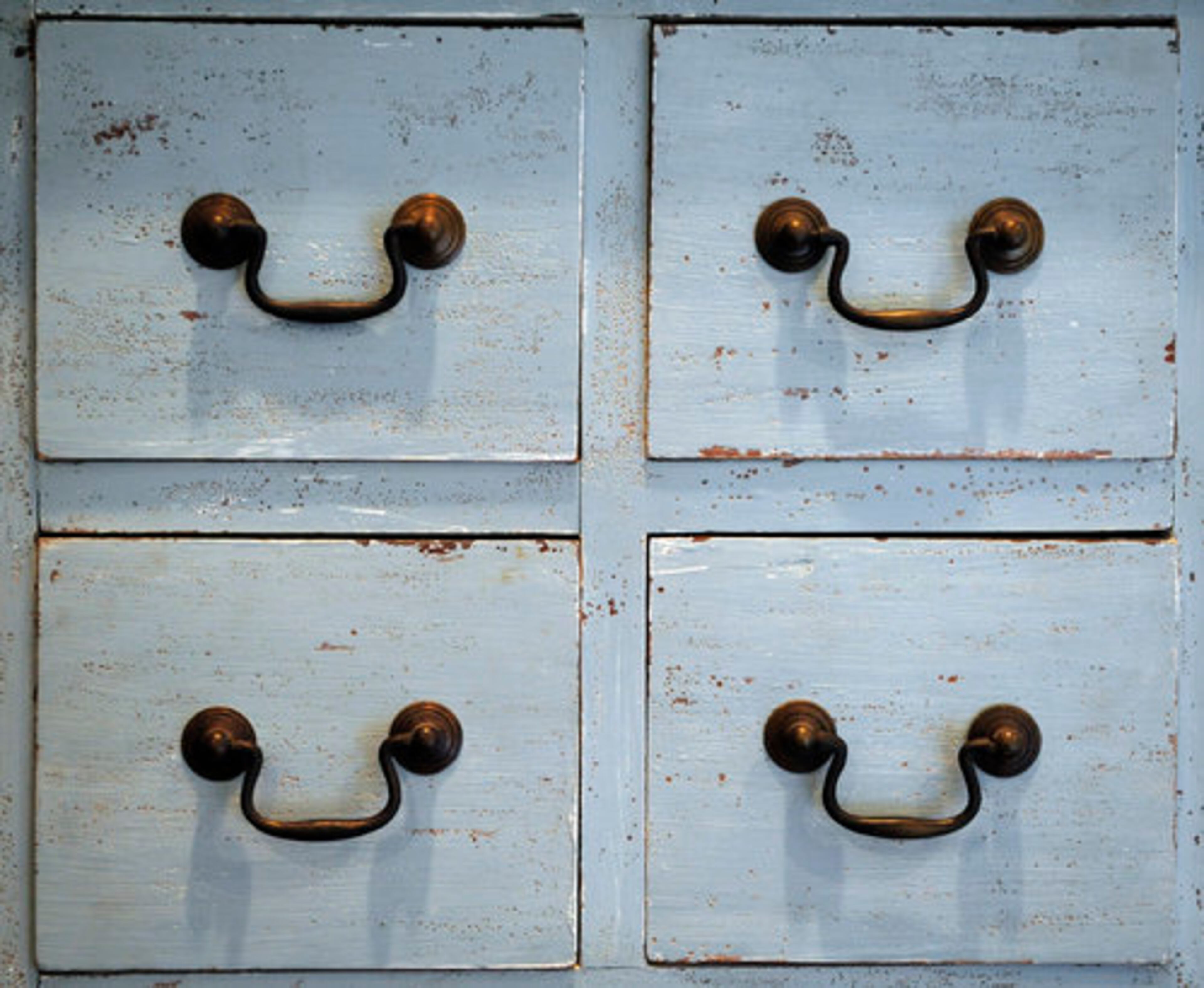 Brass pulls accent the distressed antique finish of a chest in one of the guest rooms.
