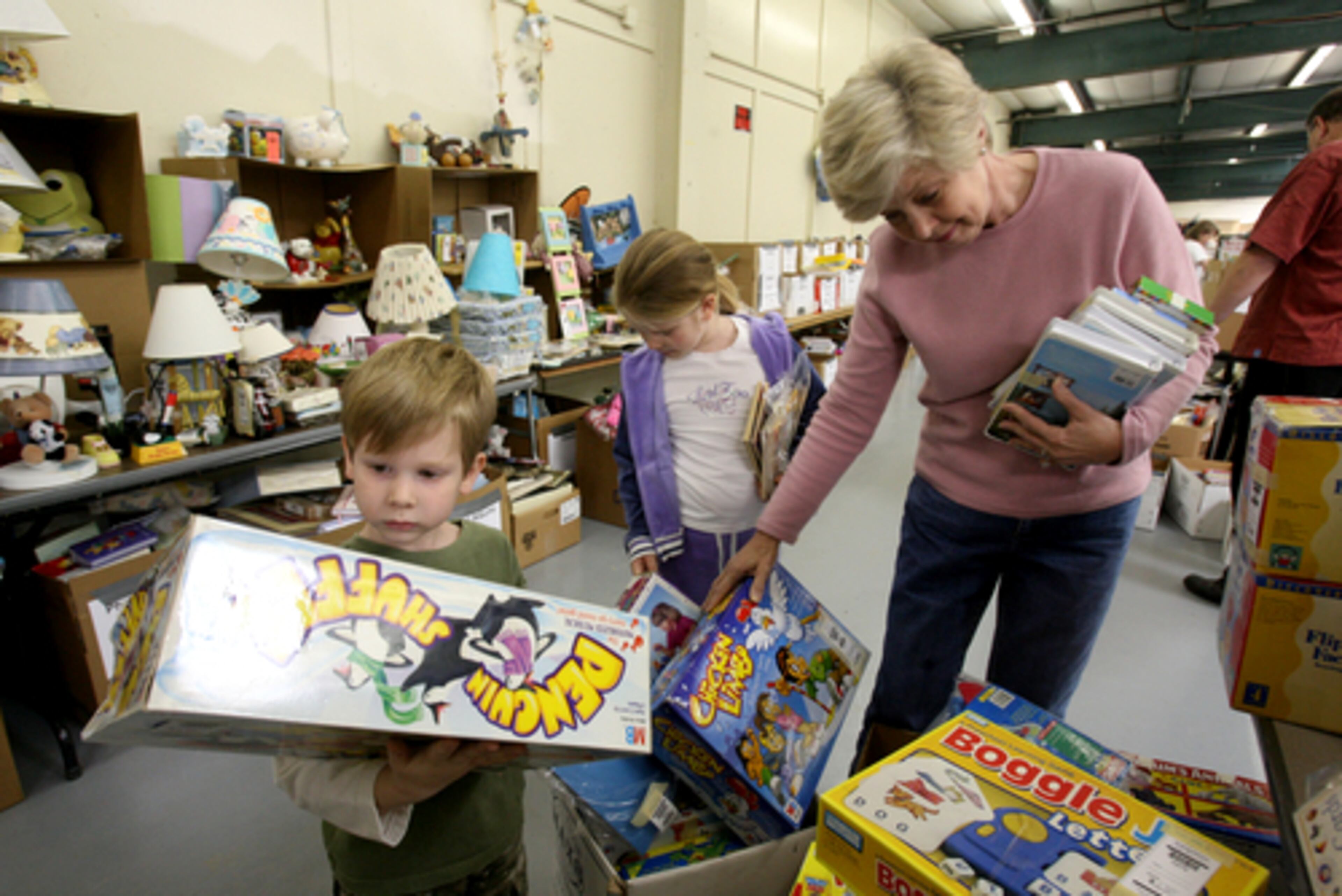 June Wilson,right, pink sweater, of Duluth, and two of her grandchildren, Trey Davis, 5, (far left) and Trey's sister, Ansley Davis, 7, (center) also of Duluth, look through toys.