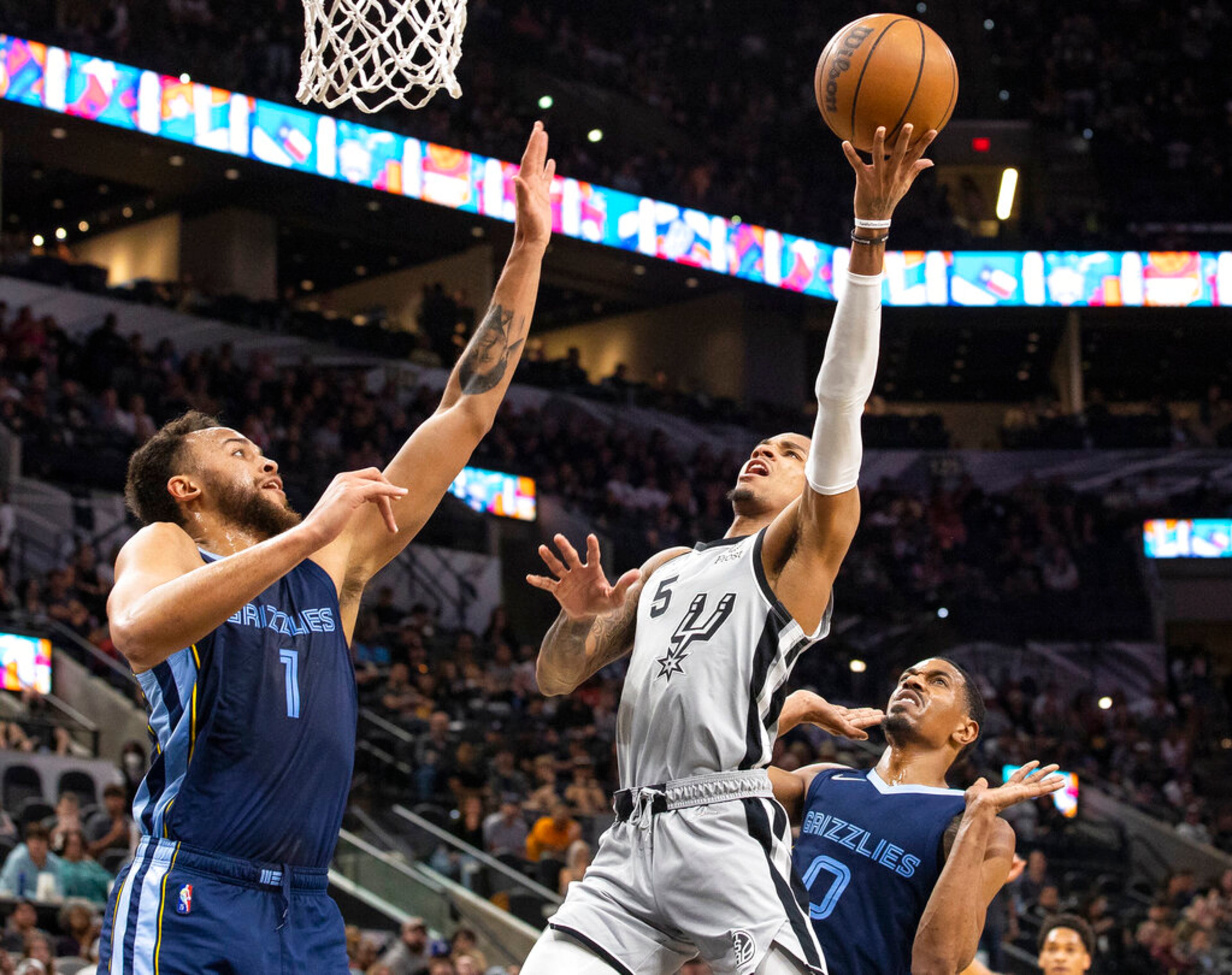 Memphis Grizzlies forward Kyle Anderson (1) defends as San Antonio Spurs guard Dejounte Murray (5) shoots during the first half of an NBA basketball game Wednesday, March 30, 2022, in San Antonio. (AP Photo/Nick Wagner)