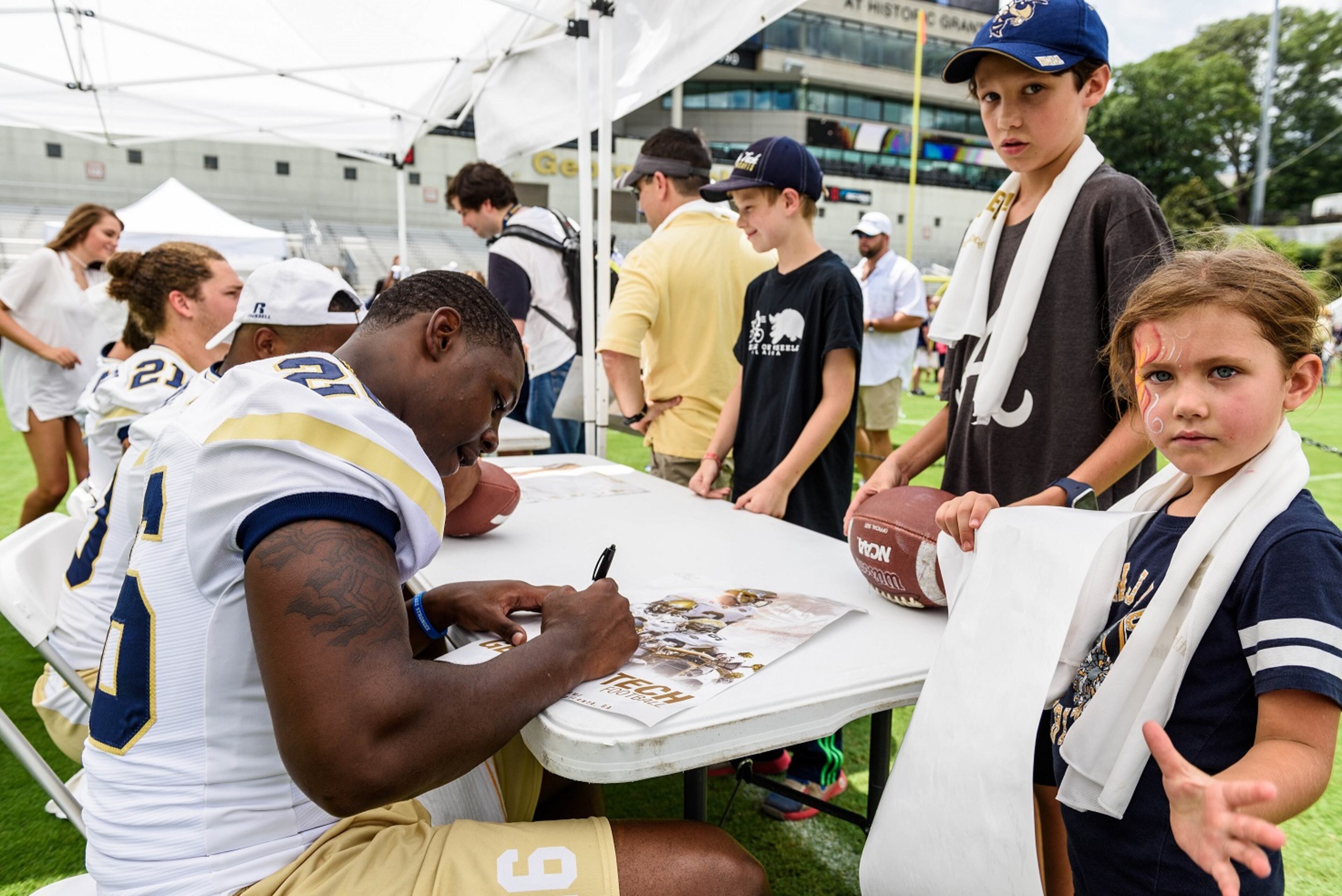 Georgia Tech B-back Dedrick Mills (26) signs autographs for Yellow Jackets fans during Fan Day at Bobby Dodd Stadium on Aug. 12, 2017. -- Danny Karnik/GT Athletics