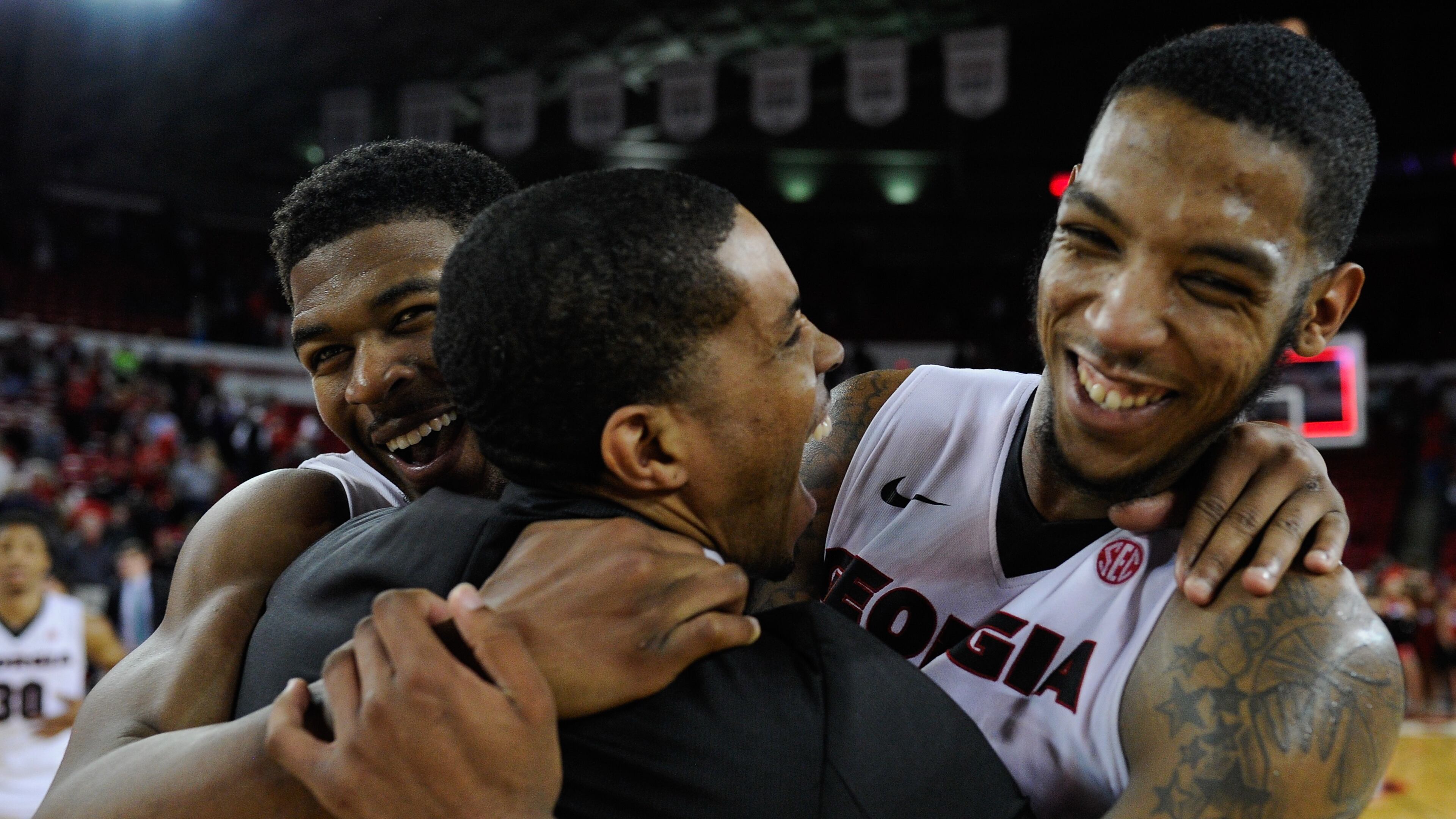 Georgia guards Kenny Gaines, left, and guard Charles Mann, right, hug assistant coach Yasir Rosemond after their 70-63 win over Alabama in an NCAA college basketball game, Saturday, March 5, 2016, in Athens, Ga. (AJ Reynolds/Athens Banner-Herald via AP) MAGS OUT; MANDATORY CREDIT