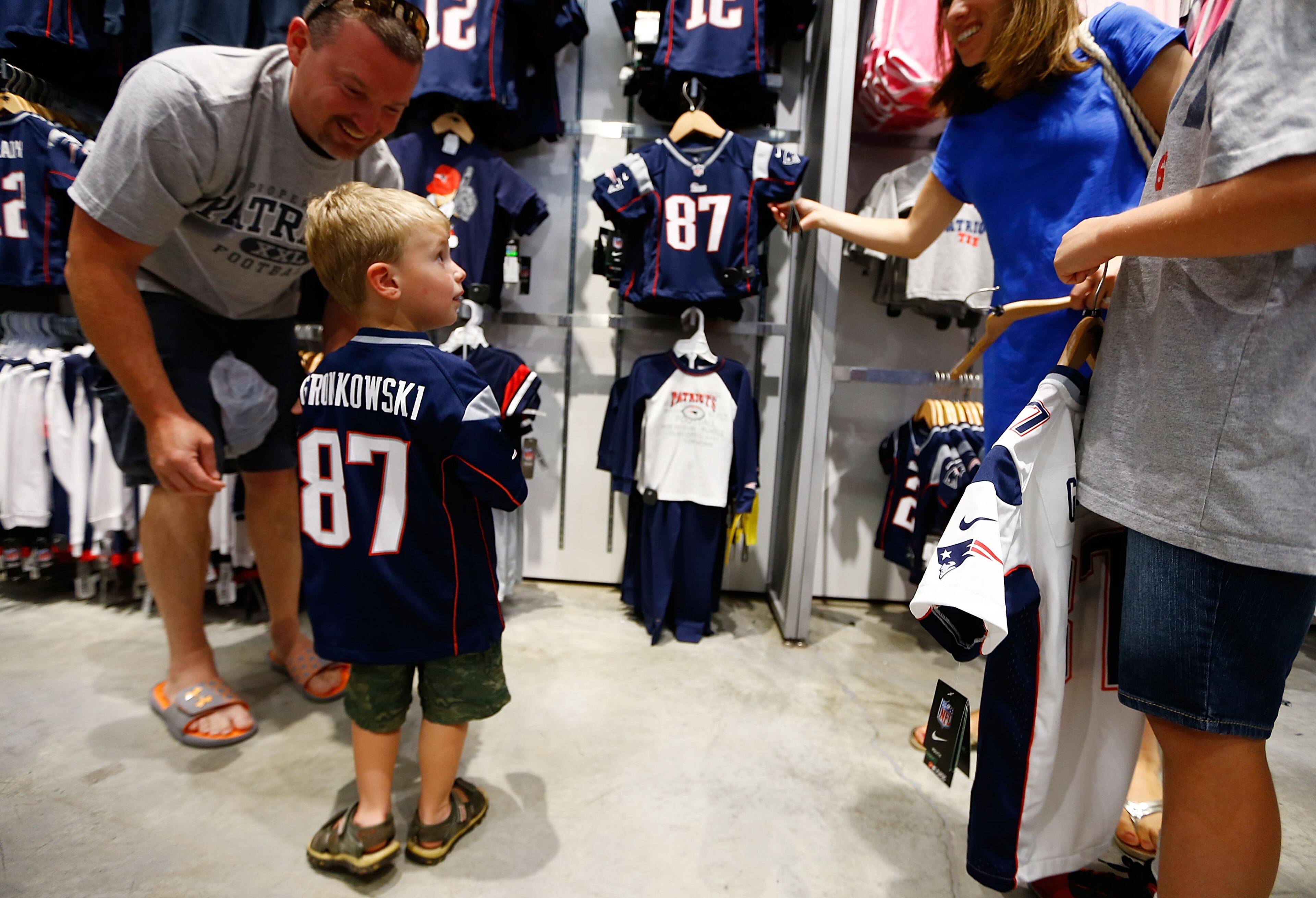 FOXBORO, MA - JULY 7: A young New England Patriots fans tries on a Rob Gronkowski jersey after exchanging their Aaron Hernandez jerseys during a free exchange at the pro shop at Gillette Stadium on July 7, 2013 in Foxboro, Massachusetts. (Photo by Jared Wickerham/Getty Images)