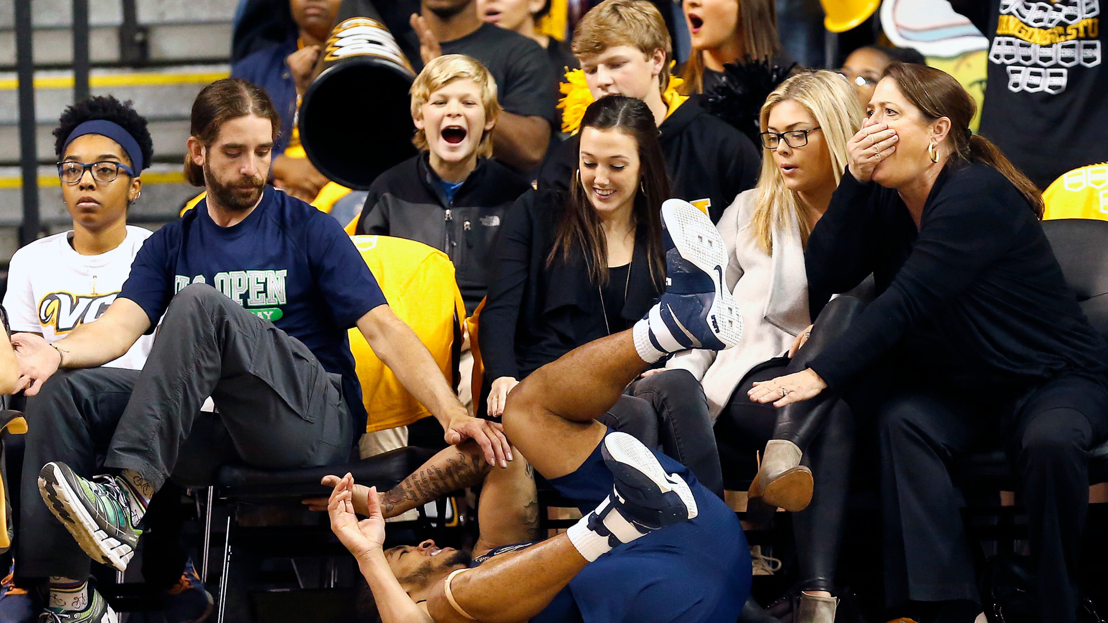 Georgia Tech’s Tadric Jackson (1) falls into the first row of the audience after colliding with Virginia Commonwealth’s Mo Alie-Cox during the first half of an NCAA college basketball game in Richmond, Va., Wednesday, Dec. 7, 2016. (Mark Gormus/Richmond Times-Dispatch via AP)