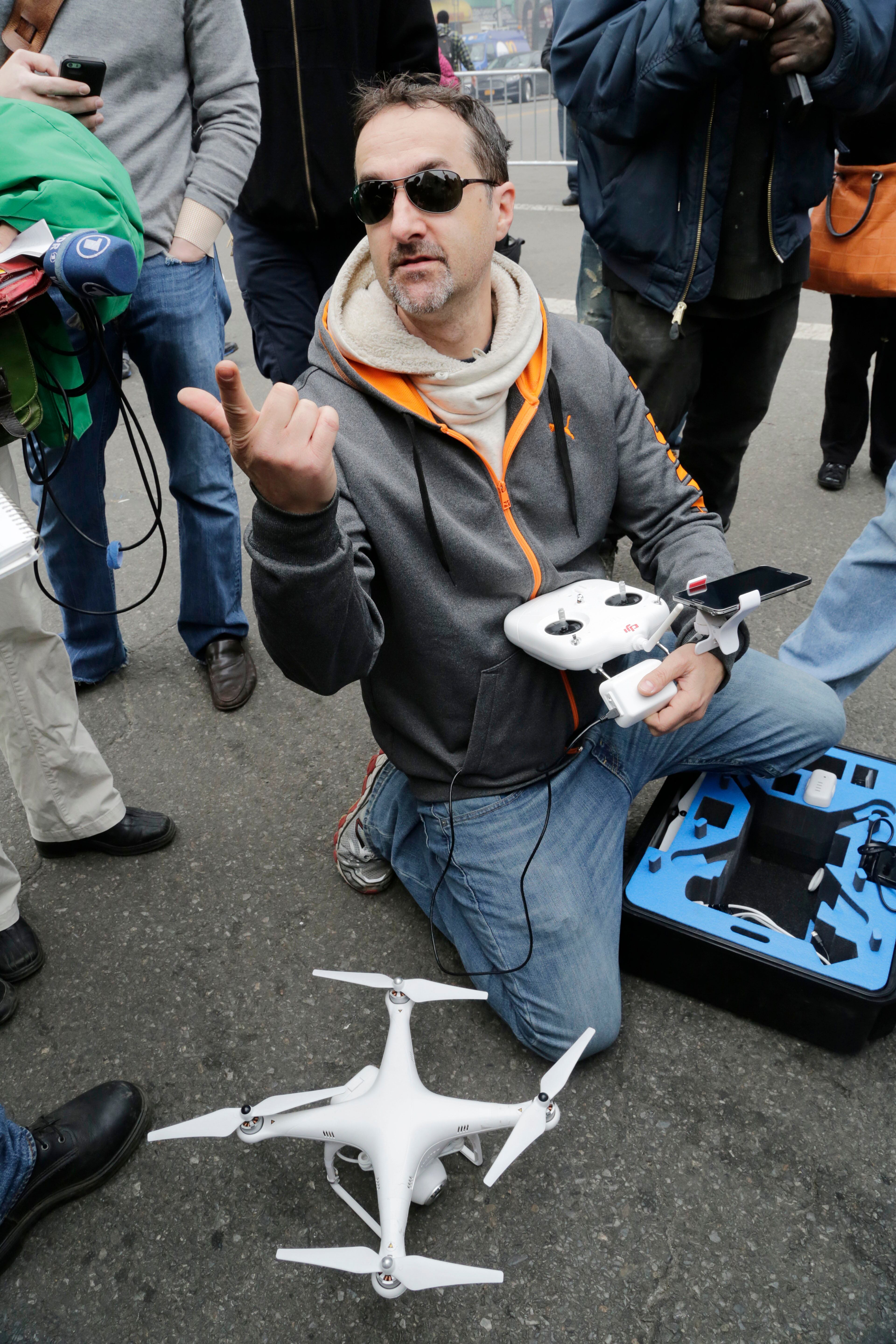 Brian Wilson packs away the drone that he was flying to video the scene of an explosion that leveled two apartment buildings in East Harlem, Wednesday, March 12, 2014, in New York. Wilson says he uses the aerial drone to document buildings, weddings and news events. (AP Photo/Mark Lennihan)