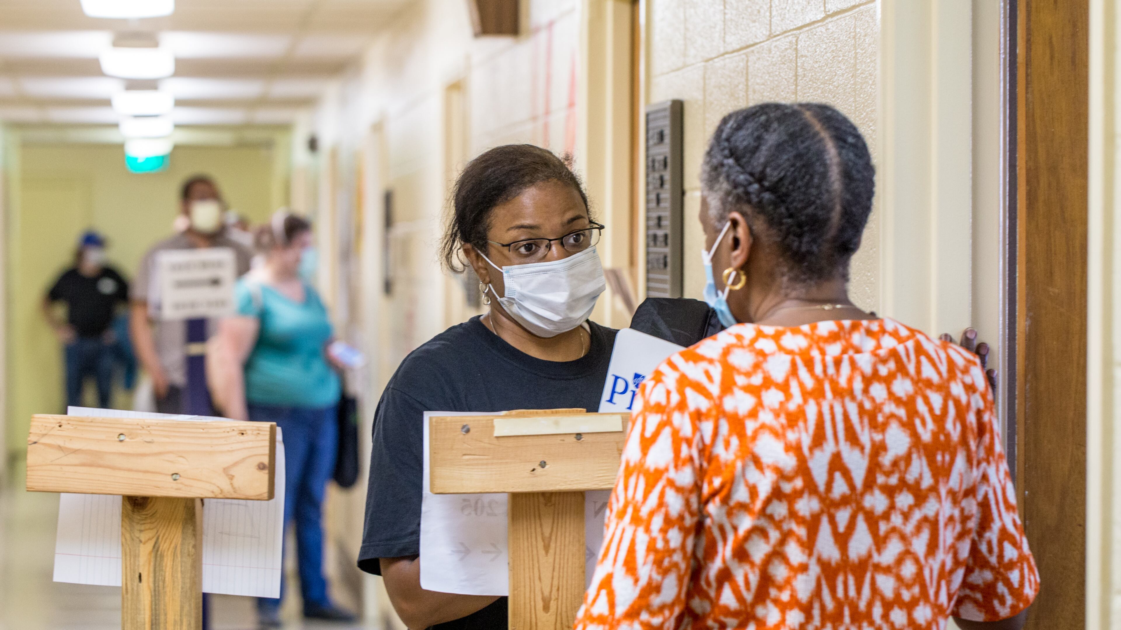 Voters wait in long lines, at times in the rain, at New Beginnings Full Gospel Church as Election Protection volunteer Angela Walker, second from right, talks with the polling location manager Tuesday, June 9, 2020. The lines were taking more than 3.5 hours. This polling location opened at 7 am with only one machine of the four available working and had two of the four working at 4:30 and were not providing provisional ballots. Walker is working on election quality control for the non-profit organization. (Jenni Girtman for The Atlanta Journal-Constitution)