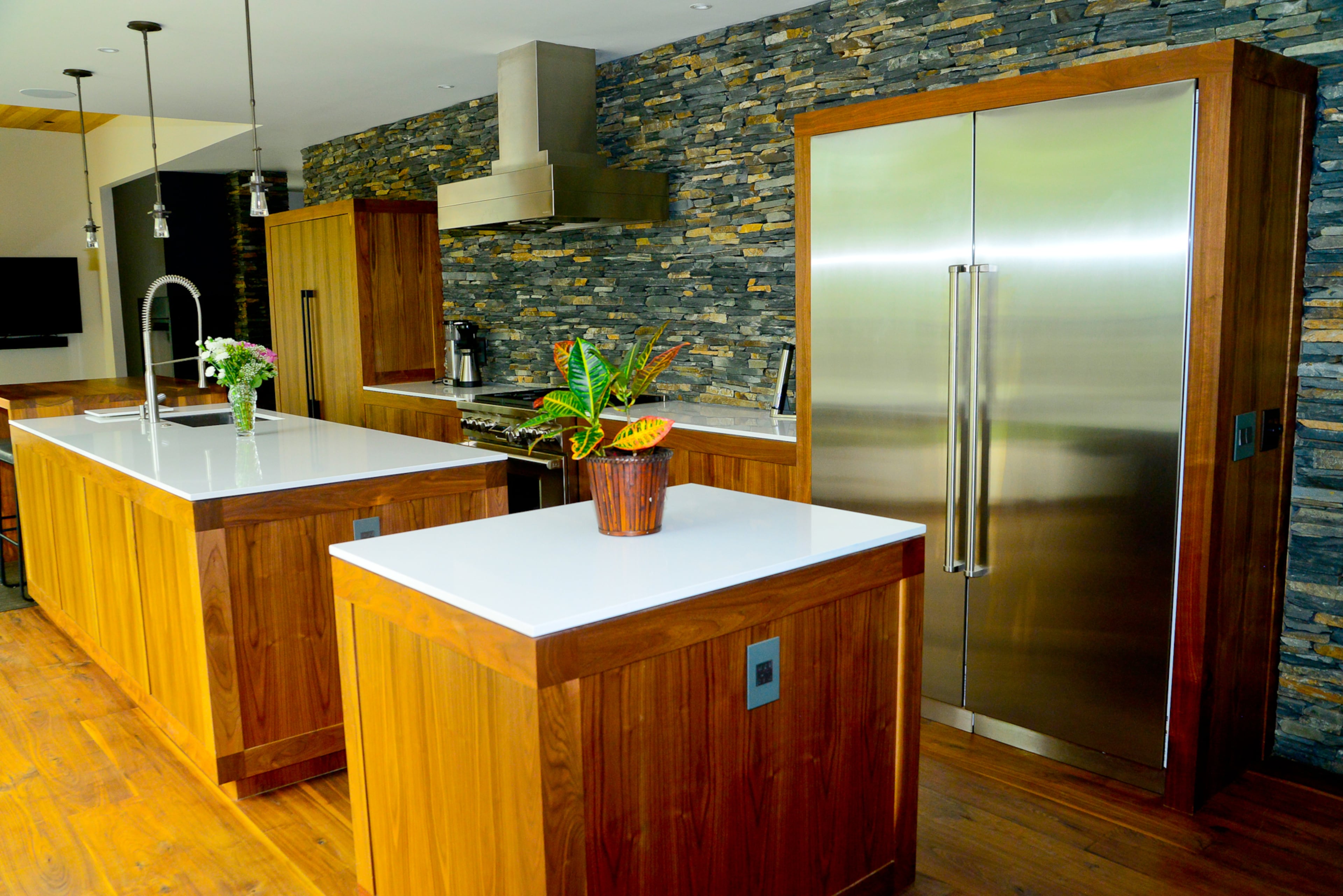 Homeowners Steve and Joann Karaga spend much of their time in the kitchen with family members and guests, and the design incorporates two islands topped with Caesarstone and a Wolf oven and refrigerator. All the cabinet pulls were custom built by Franco Iron Works in Atlanta. The handmade cabinetry by Dark Horse Woodworks retained the imperfections and weathering in the walnut wood.
