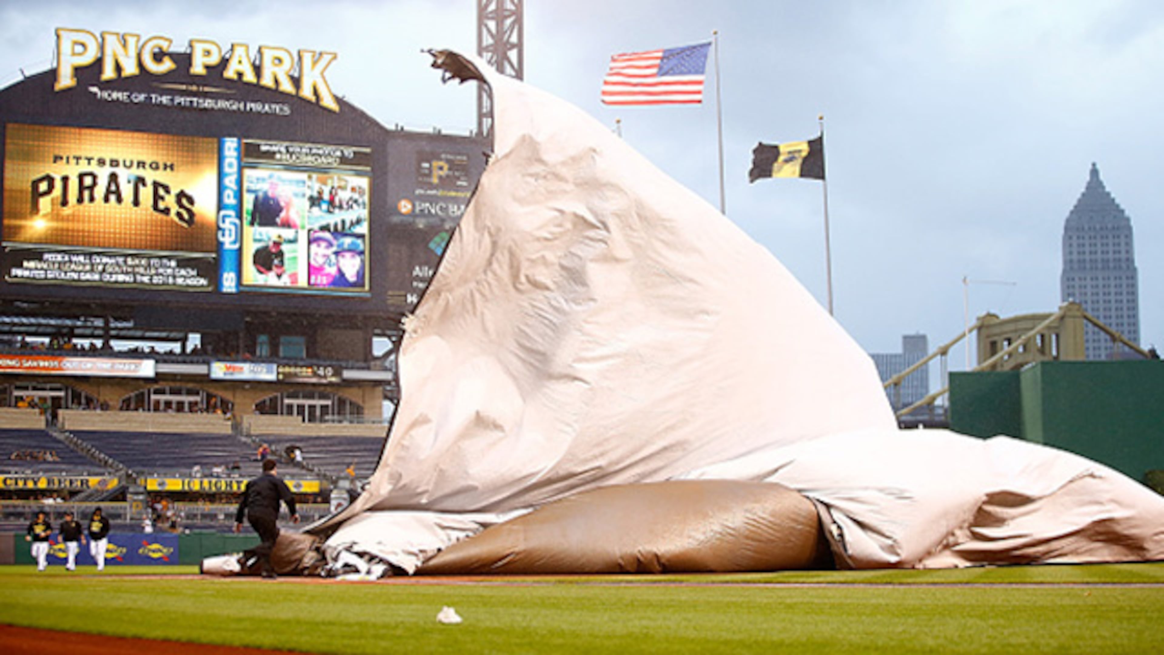 PITTSBURGH, PA - JULY 07: Members of the grounds crew get caught underneath the tarp while heavy wind and rain came down causing a rain delay between the Pittsburgh Pirates and the San Diego Padres in the third inning during the game at PNC Park on July 7, 2015 in Pittsburgh, Pennsylvania. (Photo by Jared Wickerham/Getty Images)