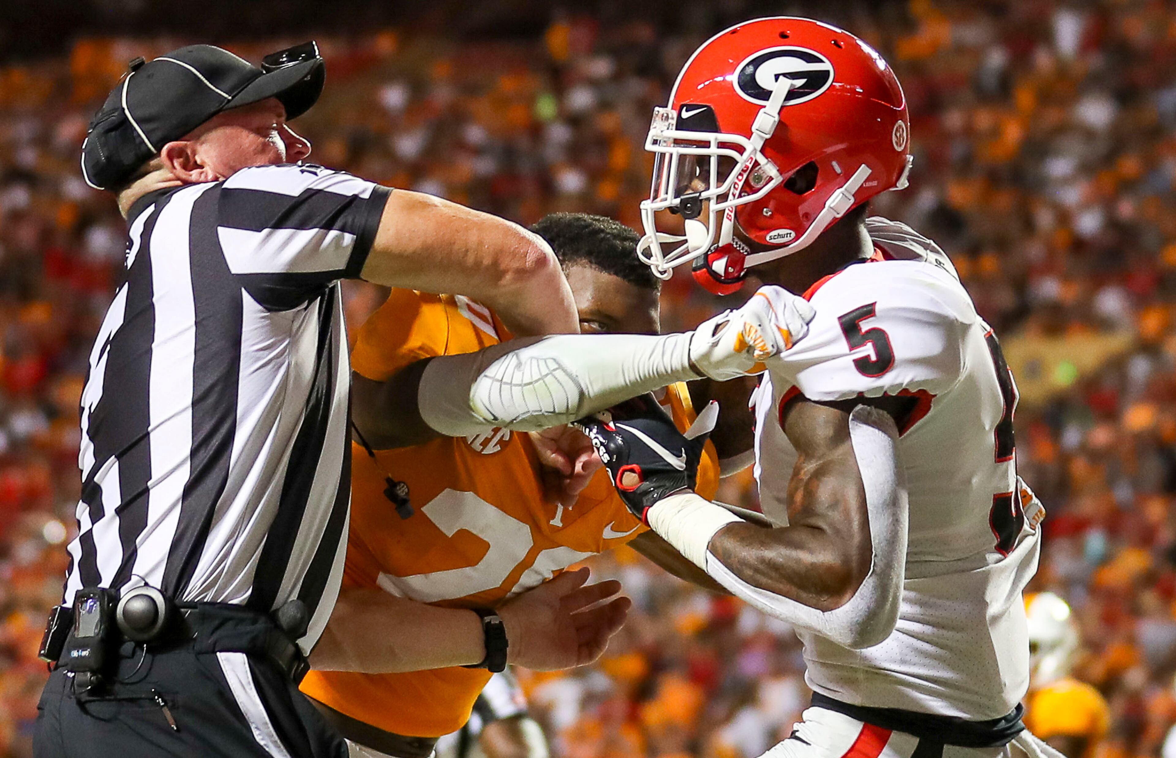 A referee breaks up a scuffle between Tennessee Volunteers defensive back Bryce Thompson (20) and Georgia Bulldogs wide receiver Matt Landers (5). (Alyssa Pointer/Atlanta Journal Constitution)