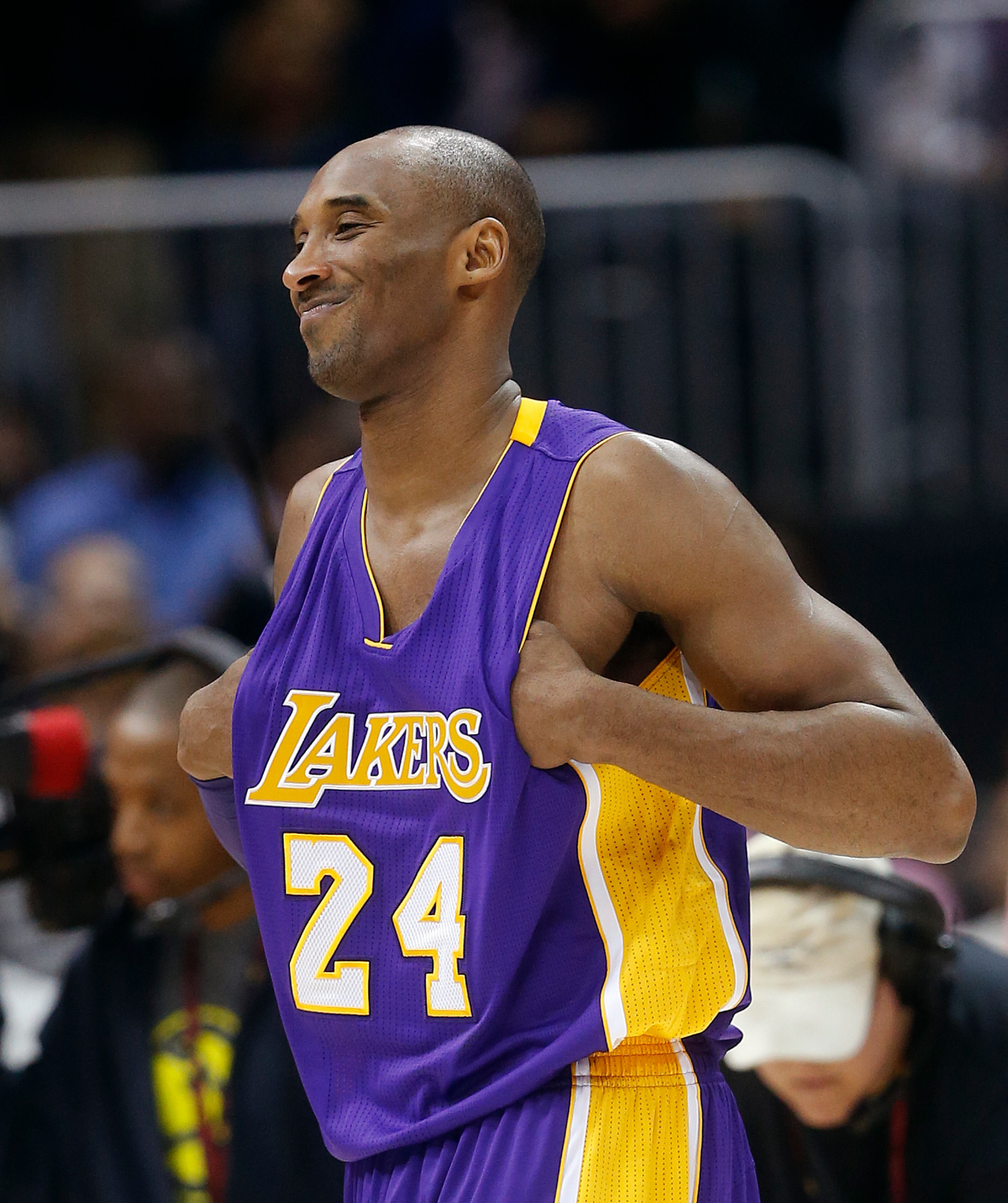Los Angeles Lakers forward Kobe Bryant (24) walks on the court after being honored during a timeout in the first half of an NBA basketball game against the Atlanta Hawks, Friday, Dec. 4, 2015, in Atlanta. Bryant says he plans to retire after the season. (AP Photo/John Bazemore)
