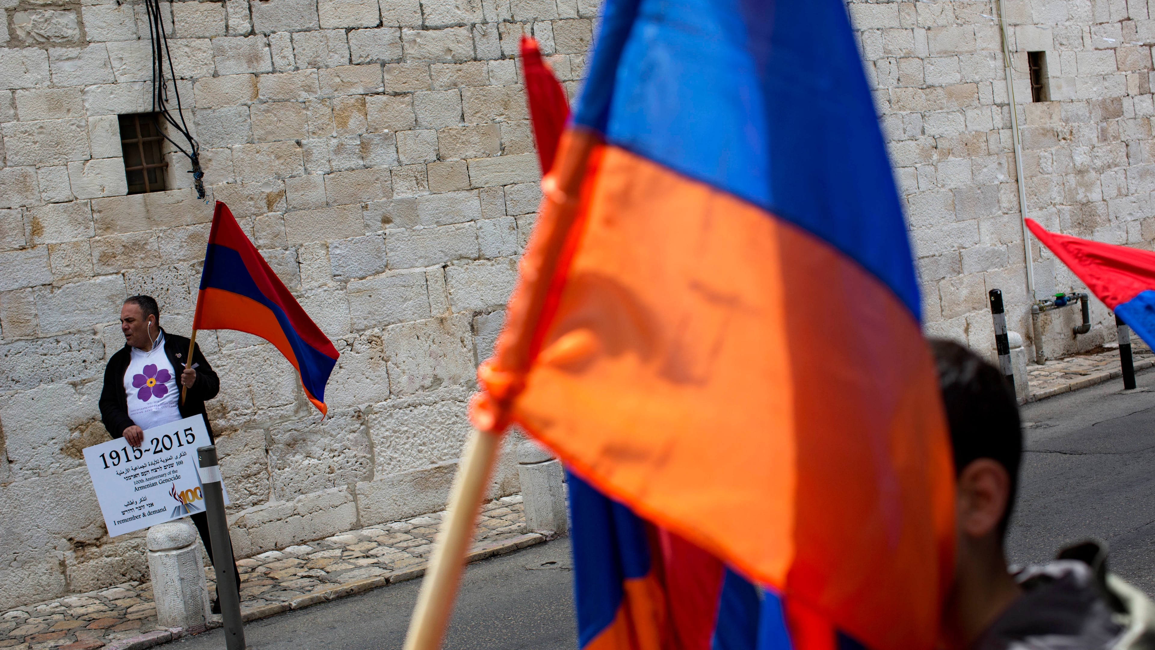 FILE - Armenians hold their national flag during a ceremony to commemorate the mass killings of Armenians by the Ottoman Empire, in Jerusalem, Israel, Friday, April 24, 2015. (AP Photo/Oded Balilty, File)