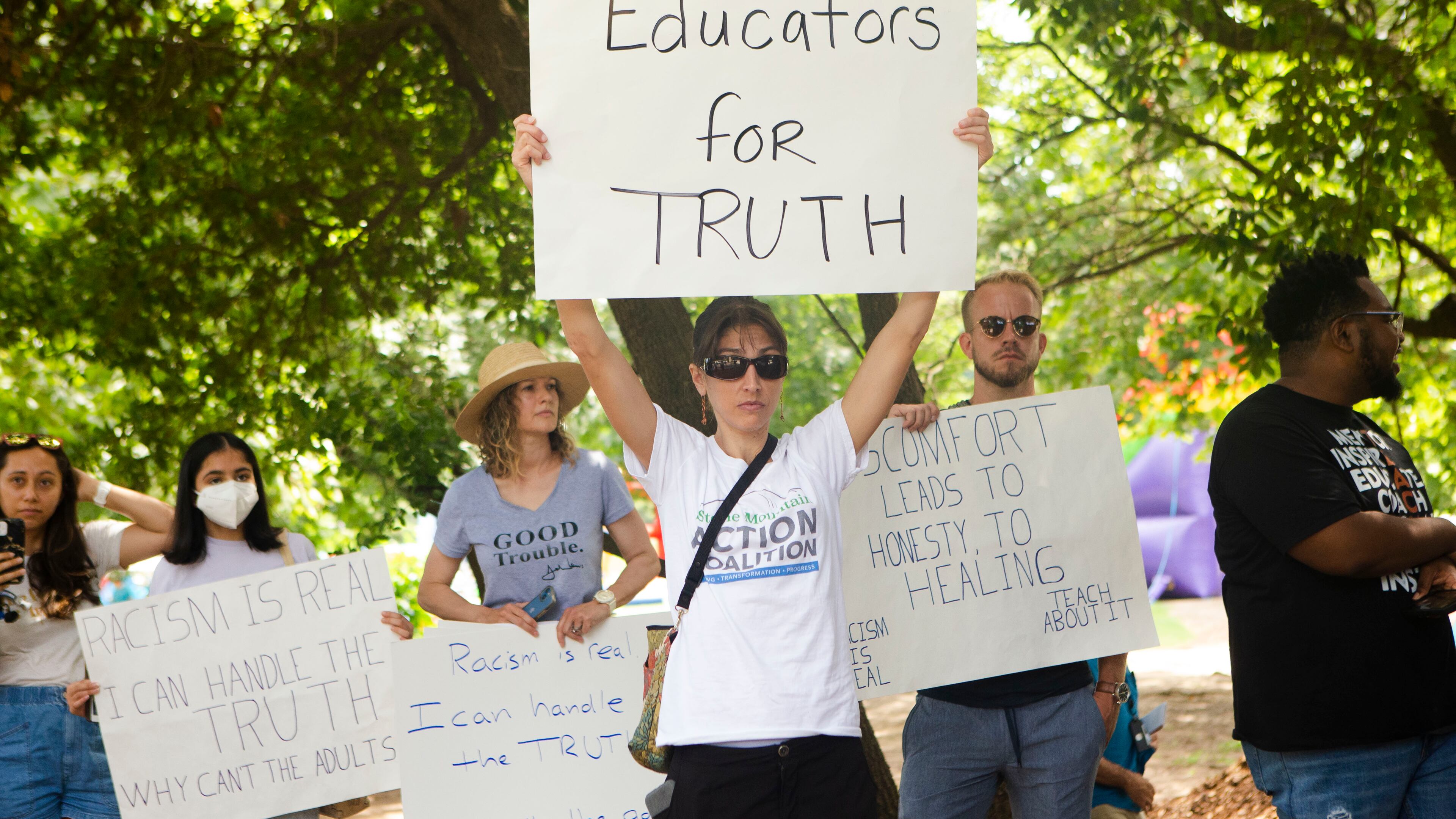 Sally Stanhope, a social studies teacher at Chamblee High School, holds up a homemade sign during a back-to-school rally for Georgia educators on Saturday, July 23, 2022, at Piedmont Park in Atlanta. Teachers, community members and students gathered to speak against new state legislative action banning selected books from school libraries and prohibiting the teaching of divisive concepts, which affected how race could be discussed in classrooms. (Christina Matacotta for The Atlanta Journal-Constitution)