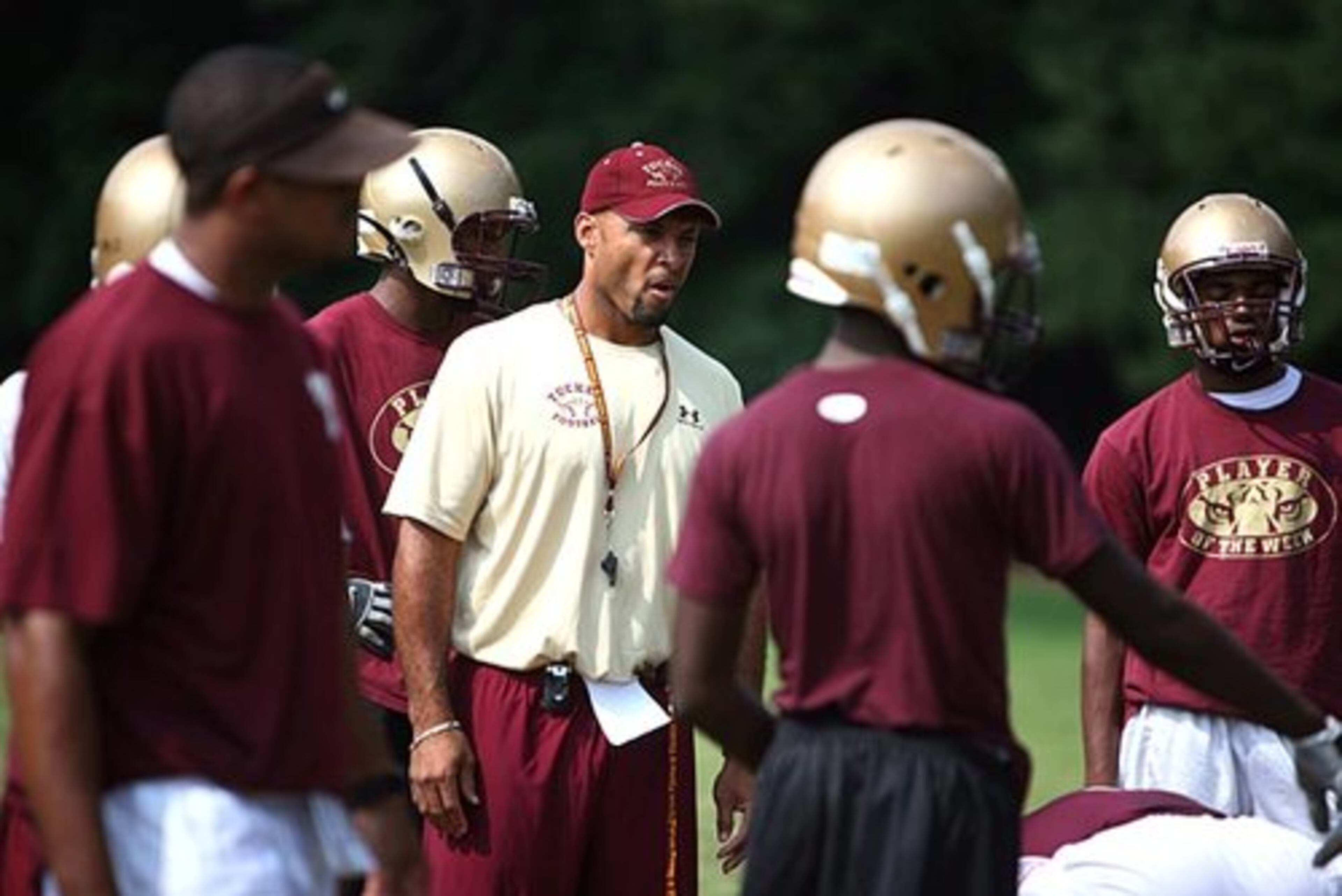 Football practice at Tucker High School: Head coach Franklin Stephens (center) instructs his athletes during workouts.