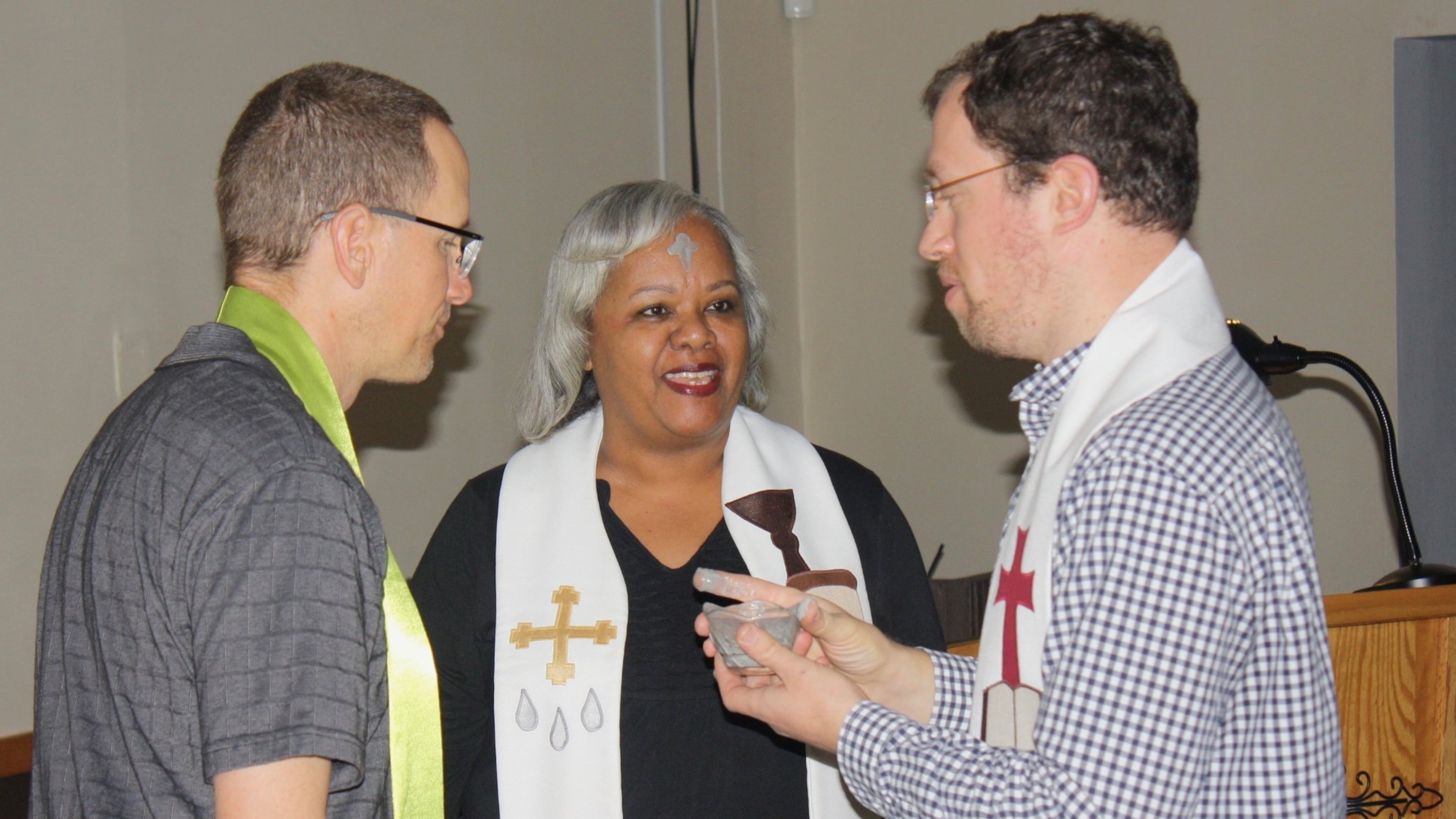 Co-pastors Tim Rodgers, left, and Catherine Gilliard speak with one of the members during an Ash Wednesday service at New Life Covenant Church. Contributed