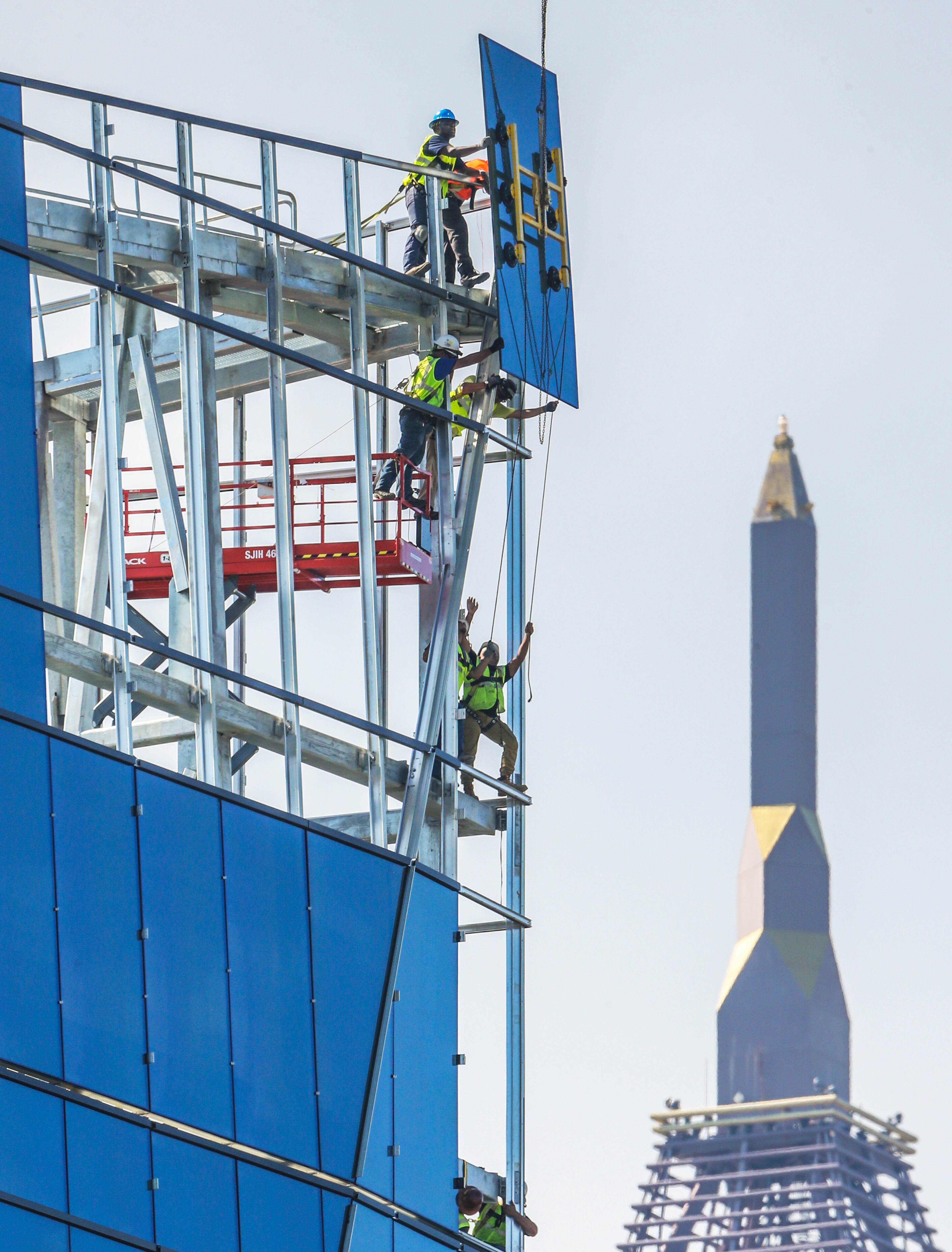 Construction has still not reached its pre-recession peaks, but the sector has grown solidly. Here a picture of workers moving glass into place on the new corporate headquarters for NCR last year. JOHN SPINK/JSPINK@AJC.COM.