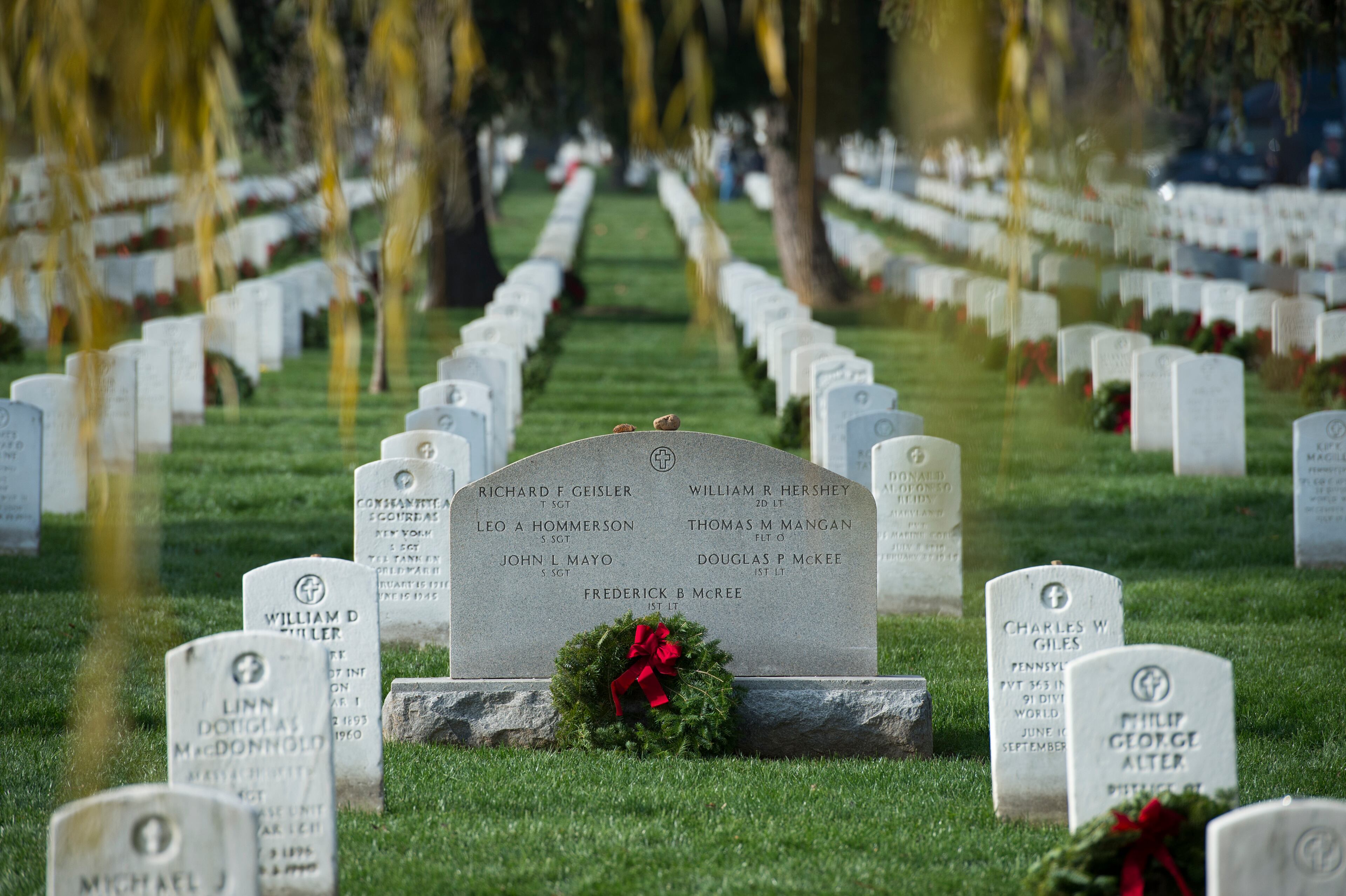 Wreaths are placed next to headstones during the 2015 National Wreaths Across America event at Arlington National Cemetery December 12, 2015 in Arlington, VA. More than 50,000 volunteers helped to place remembrance wreaths on 230,000 gravestones at Arlington on Saturday. AFP PHOTO/MOLLY RILEY / AFP / MOLLY RILEY (Photo credit should read MOLLY RILEY/AFP/Getty Images)