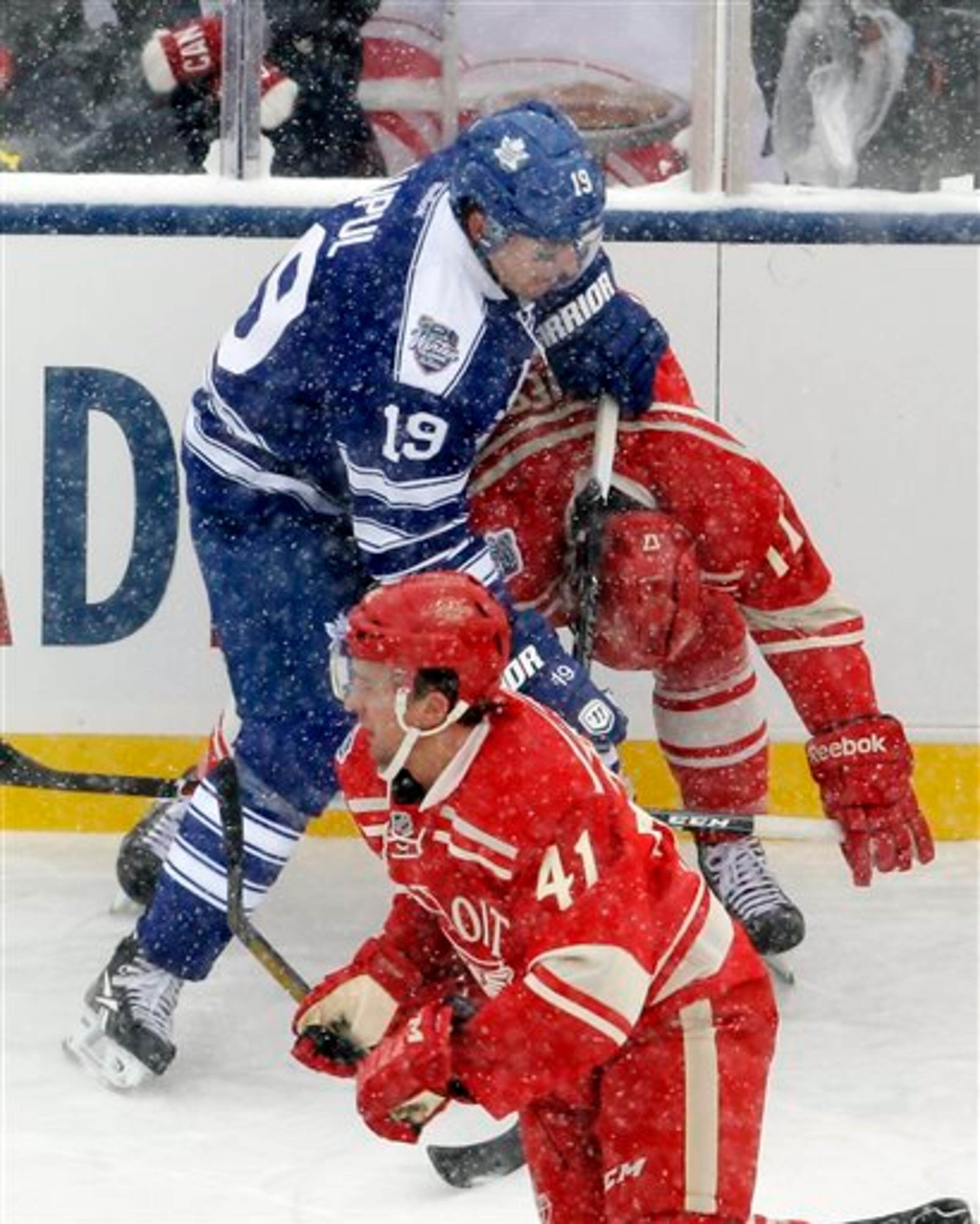 Toronto Maple Leafs right wing Joffrey Lupul (19) cross checks Detroit Red Wings forward Patrick Eaves during the first period of the Winter Classic outdoor NHL hockey game at Michigan Stadium in Ann Arbor, Mich., Wednesday, Jan. 1, 2014. Lupul received a two-minute penalty, and Eaves left the ice after hit. (AP Photo/Carlos Osorio)