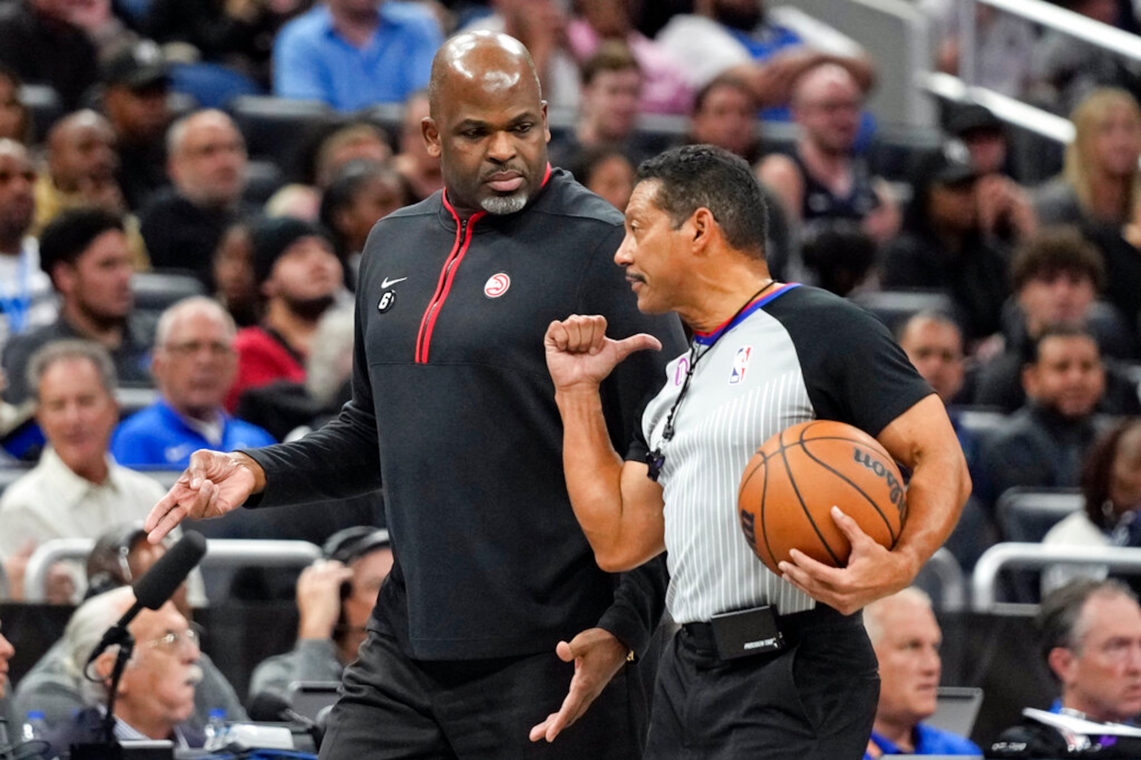 Atlanta Hawks head coach Nate McMillan, left, discusses a ruling with official Bill Kennedy during the first half of an NBA basketball game, Wednesday, Dec. 14, 2022, in Orlando, Fla. The Hawks lost 135-124. (AP Photo/John Raoux)