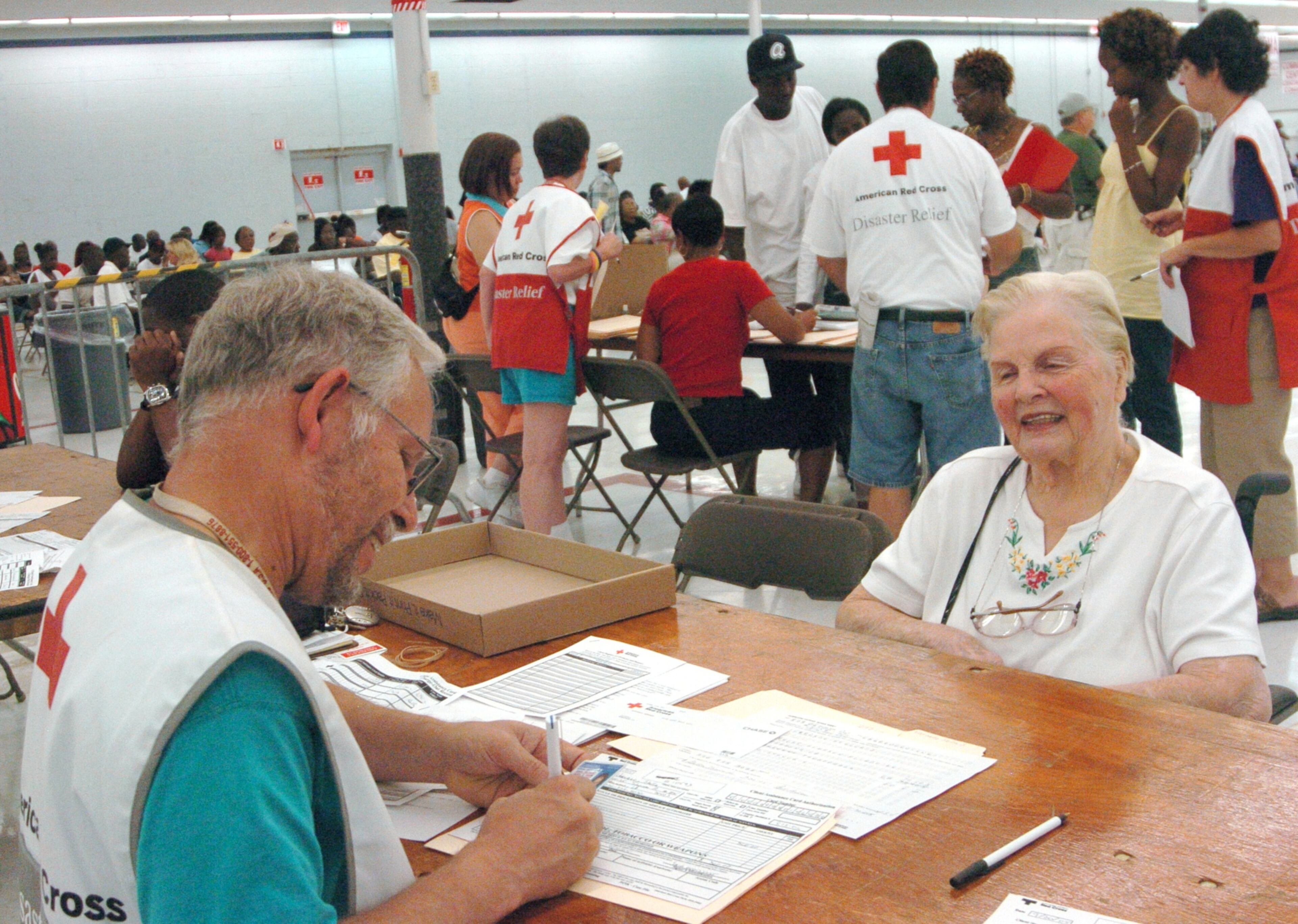 050920 LAWRENCEVILLE - Red Cross center - (l to r) Hal Simmons (Norcross) volunteer helping Stella Varnado (85)(former Army Air Corps nurse during WWII and after the war in New Orleans) evacuee from New Orleans, get assistance payment (all cq)(Tues. 9/20/5)(NICK ARROYO/STAFF PHOTO)