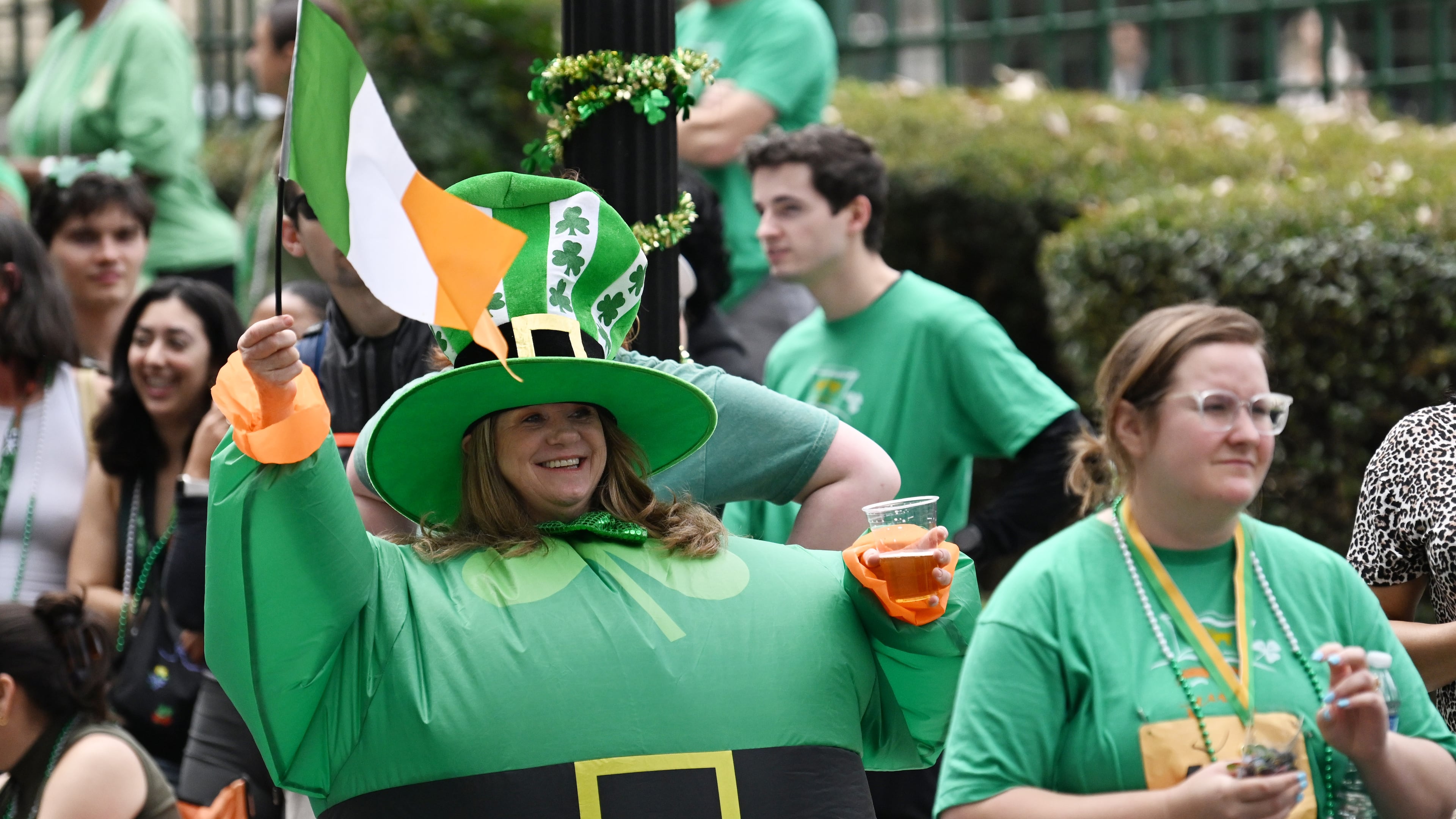 Spectators react as the floats head down Peachtree Street during the Atlanta St. Patrick's Parade, Saturday, March 15, 2025, in Atlanta. The parade begins at noon at the corner of 15th and Peachtree streets and will continue south along Peachtree to 5th Street. Everyone is encouraged to be Irish for the day as they watch the parade, which is filled with floats, bands, bagpipe and drum corps, dancers, clowns, drill teams and more. (Hyosub Shin / AJC)