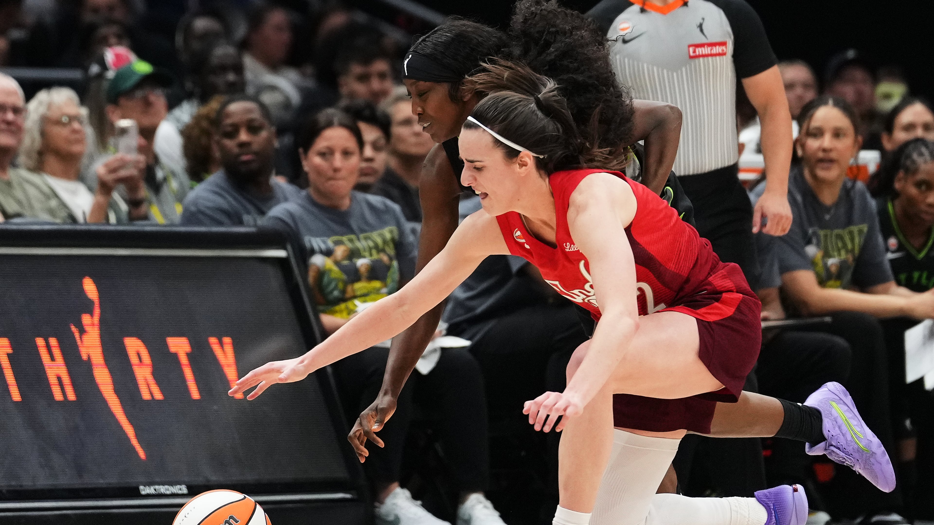 Seattle Storm guard Flau'jae Johnson, back, reaches for the ball against Indiana Fever guard Caitlin Clark, front, during the second half of a WNBA basketball game, Tuesday, July 28, 2026, in Seattle. (AP Photo/Lindsey Wasson)