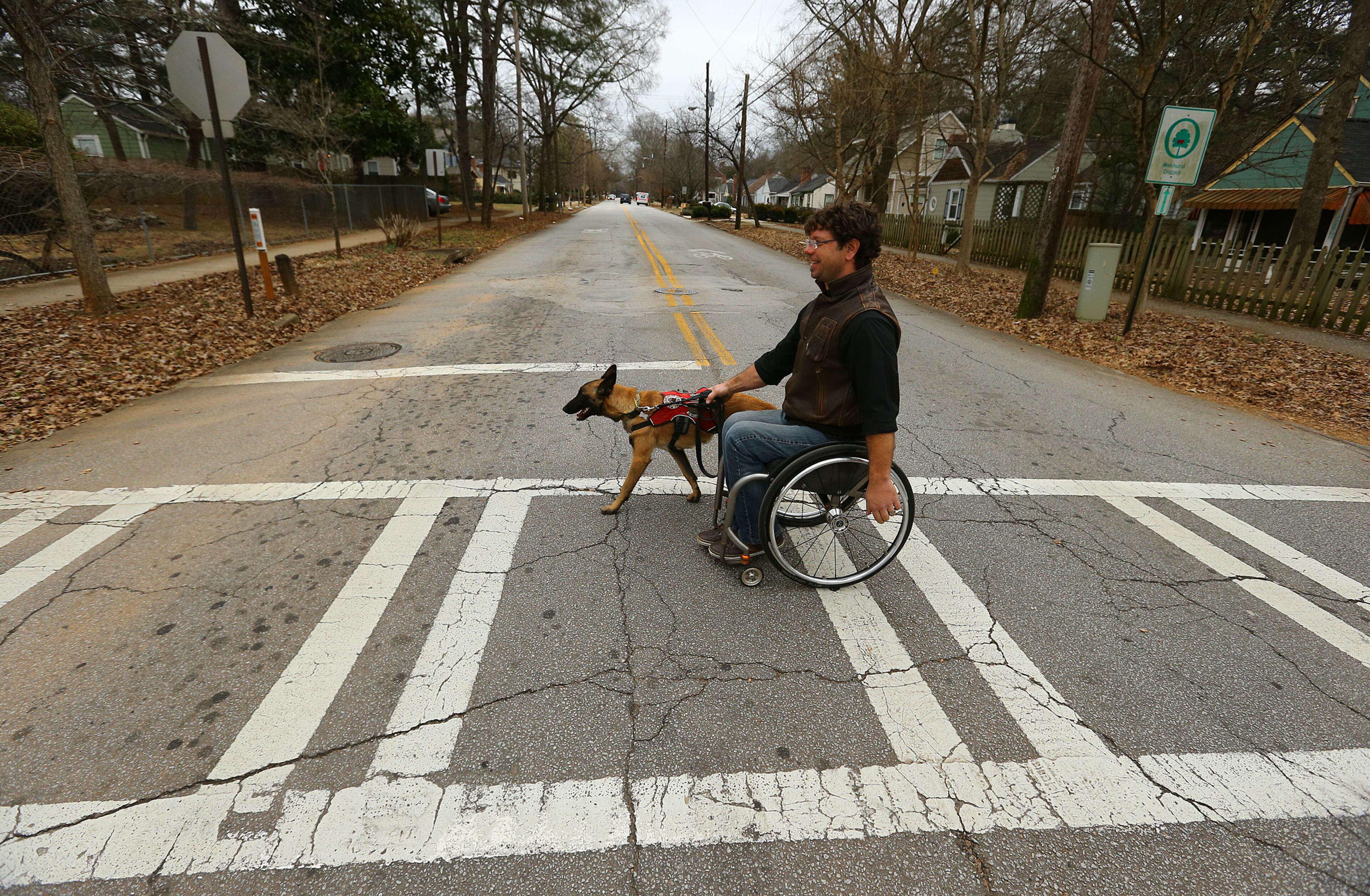 Wheelchair racer Pete Anziano and his dog Amelie cross the street from their home during their afternoon stroll and training session. Click here to read more about Anziano, his dogs and his sport.