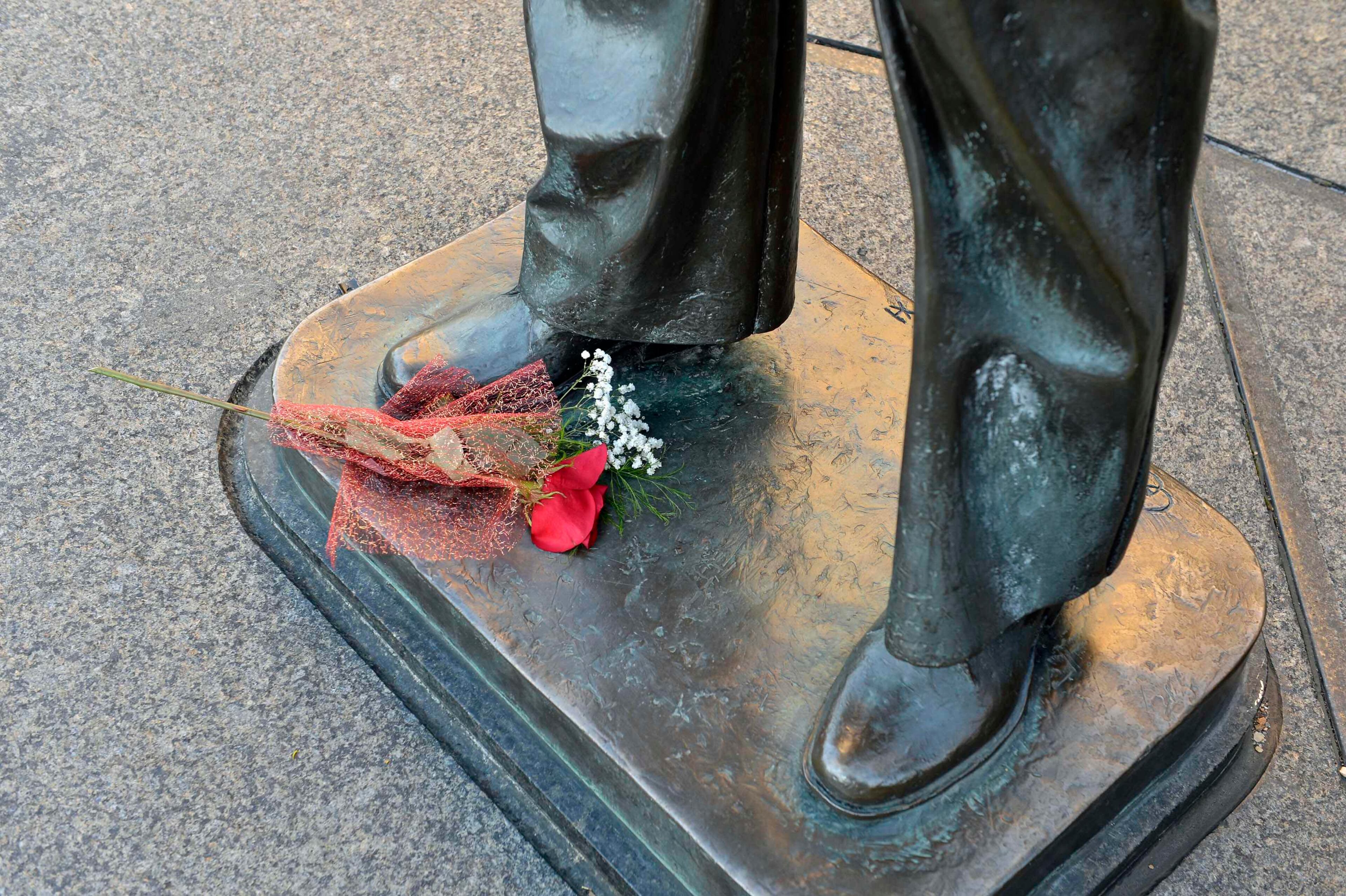 A lone bouquet of flowers is left at the base of a statue at the Navy Memorial in Washington, to honor the victims of the attack at the Navy Yard, September 17, 2013. Washington authorities questioned on Tuesday how a U.S. military veteran with a history of violence and mental problems could have gotten clearance to enter a Navy base where he killed 12 people before police shot him dead. The suspect, Aaron Alexis, 34, a Navy contractor from Fort Worth, Texas, entered Washington Navy Yard on Monday morning and opened fire, spreading panic at the base just a mile and a half (2.5 km) from the U.S. Capitol and three miles (4.8 km) from the White House.REUTERS/Mike Theiler