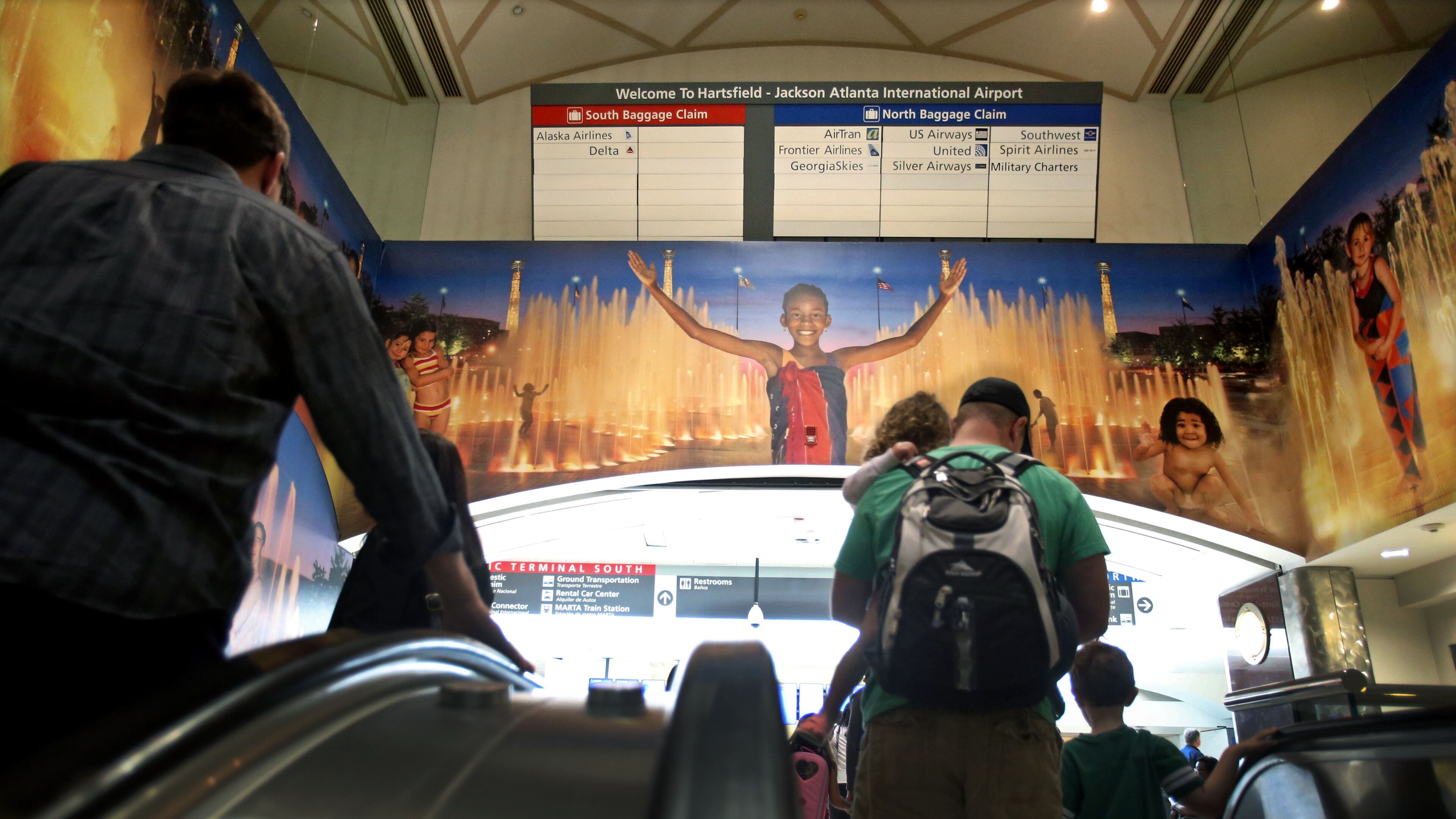 April 23, 2013 - Atlanta, Ga: After traveling on the automated people movers, paassengers travel up the long escalator where the well-known mural welcomes visitors to Atlanta at Hartsfield-Jackson Atlanta International Airport Tuesday morning in Atlanta, Ga., April 23, 2013. Nearly a year after the Atlanta airport opened its new international terminal, it is already planning for the next expansion. Hartsfield-Jackson International Airport's master plan study shows the airport will soon need more parking, and will also need more people-mover train capacity inside the terminal, more security screening line space, more gates and more airfield capacity - such as another runway -- in the next 20 years JASON GETZ / JGETZ@AJC.COM