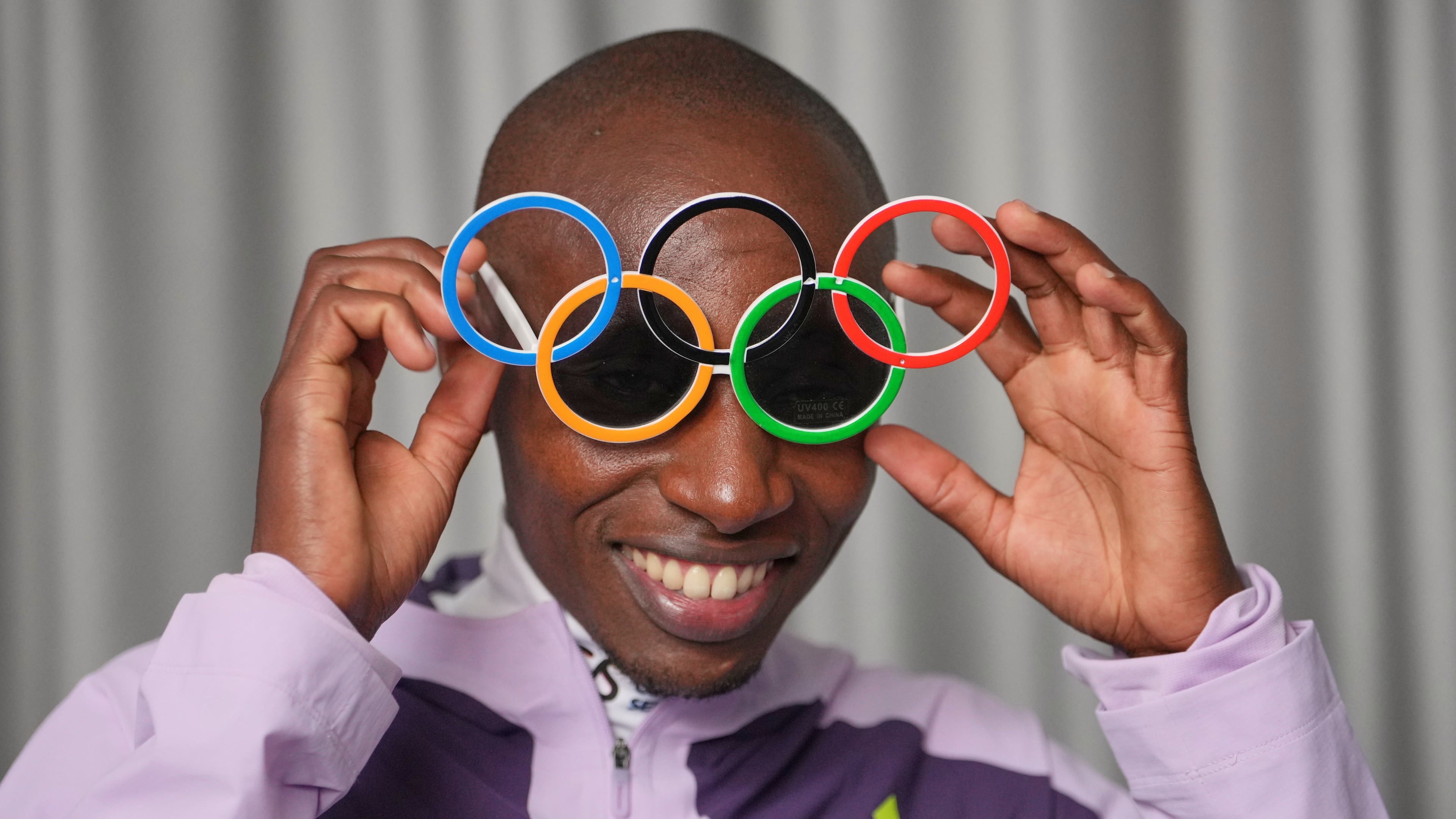 Kenya's Sabastian Sawe poses with Olympic Ring sun-glasses during an interview with The Associated Press after winning the London Marathon, in London, Monday, April 27, 2026. (AP Photo/Kin Cheung)