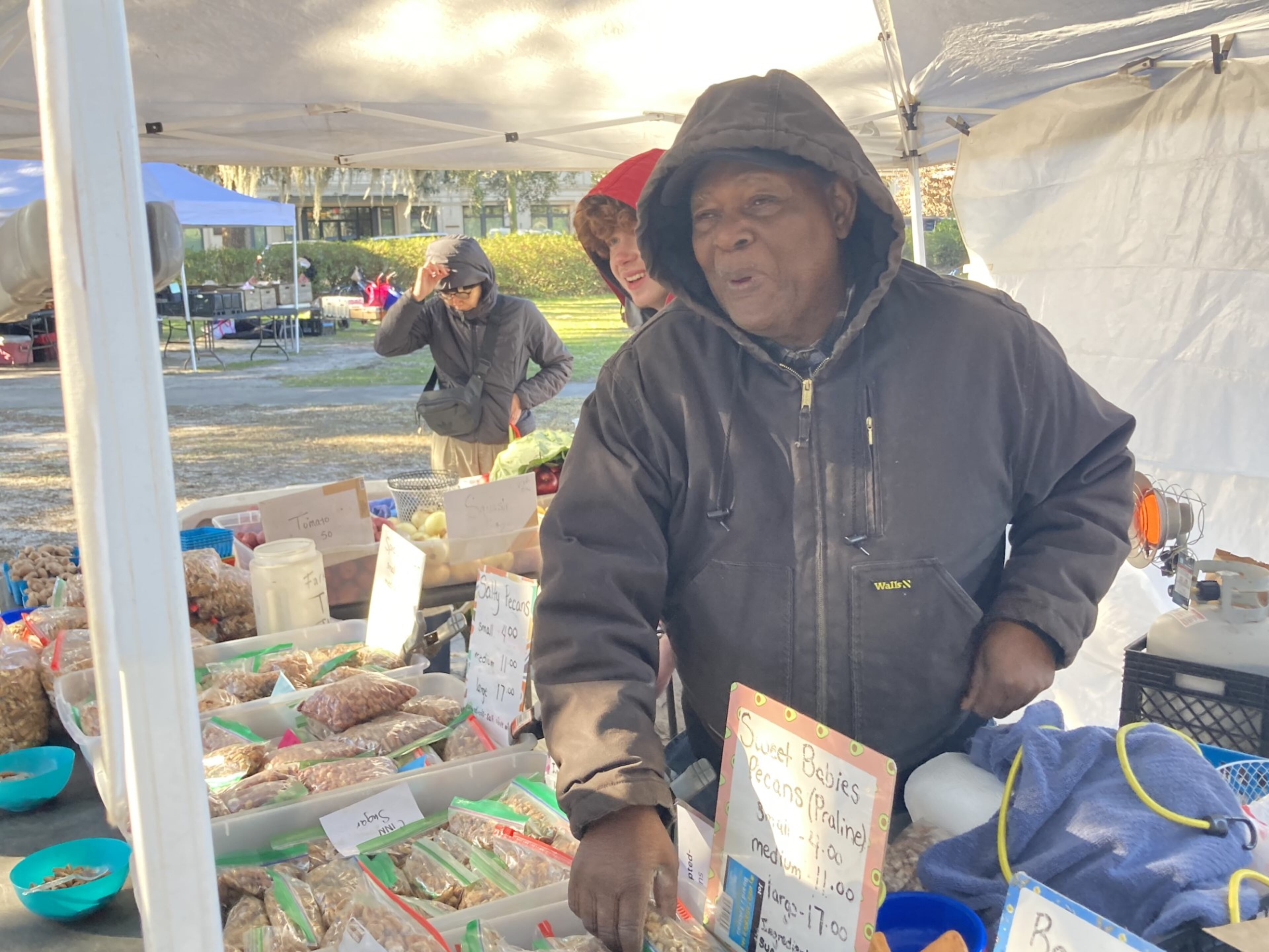Joe King, aka "Farmer Joe," sells produce from the C&S Farm in Portal at the Forsyth Farmers Market. King says his nickname is misleading - he doesn't farm C&S's 200 acres but instead acts as the farm's head salesman. (Adam Van Brimmer/adam.vanbrimmer@ajc.com)
