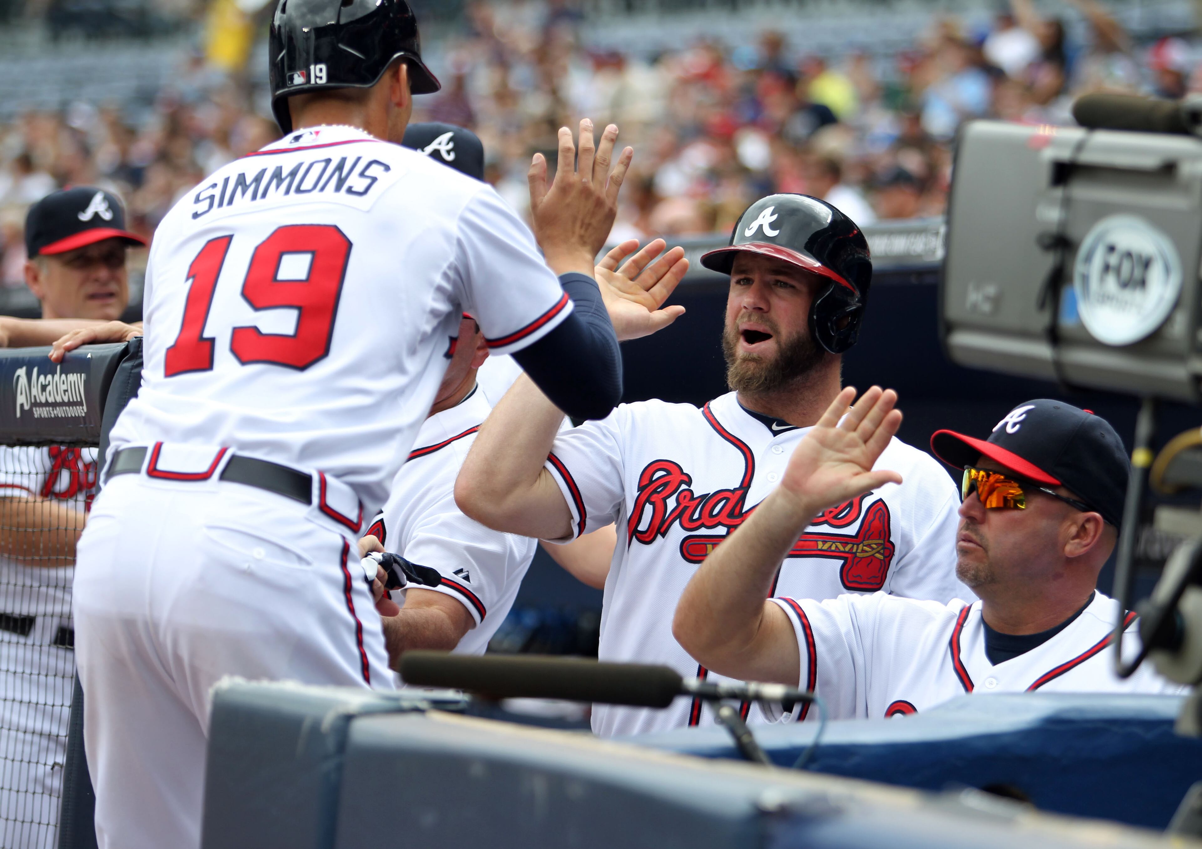 Braves shortstop Andrelton Simmons, left, celebrates with left fielder Evan Gattis, center, and manager Fredi Gonzalez in 2013.