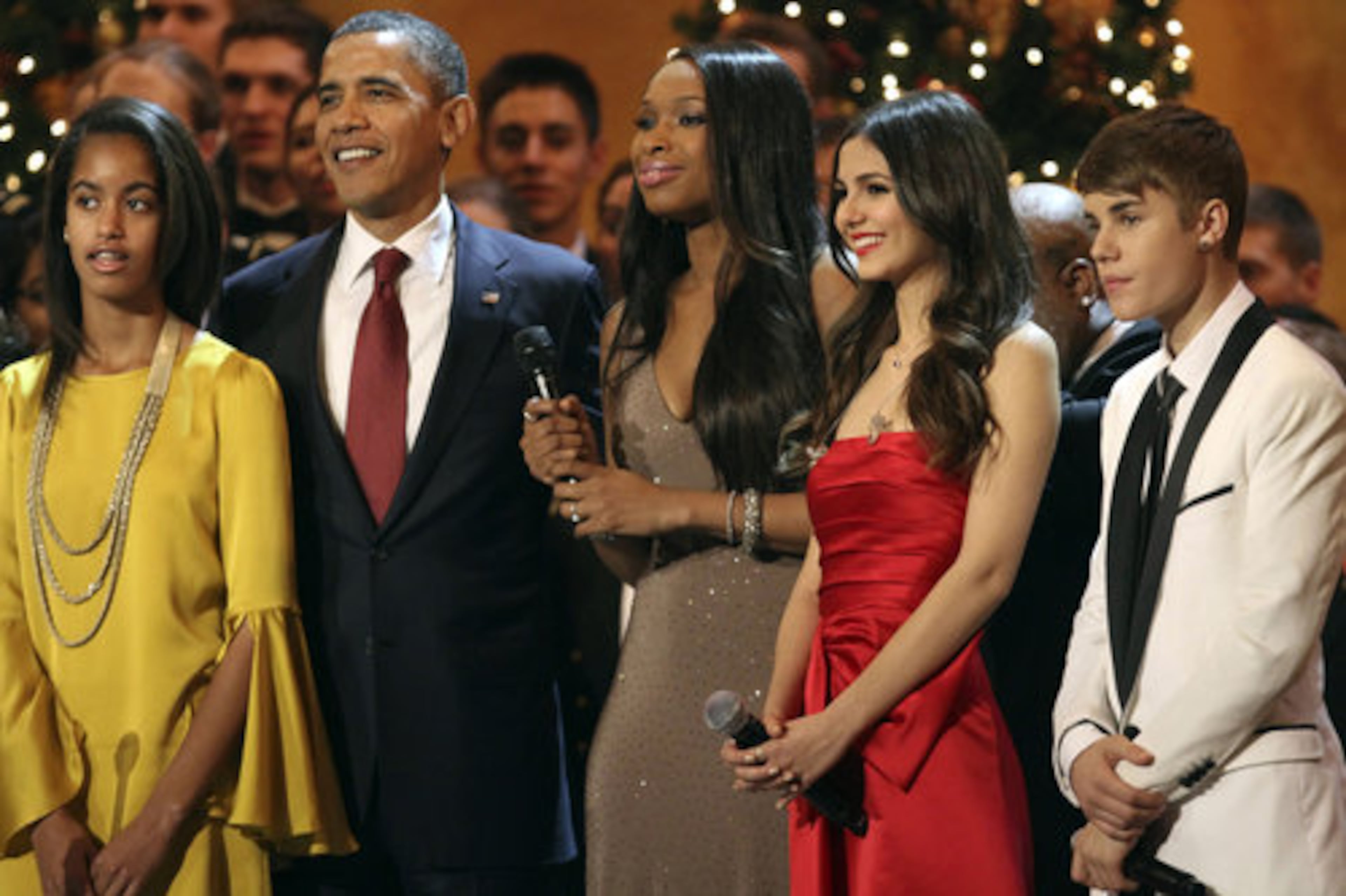 From left, Malia Obama, President Barack Obama, and performers Jennifer Hudson, Victoria Justice, and Justin Bieber, stand on stage before singing "Hark! The Herald Angels Sing" at the annual Christmas in Washington taping at the National Building Museum in Washington, Sunday, Dec. 11, 2011.