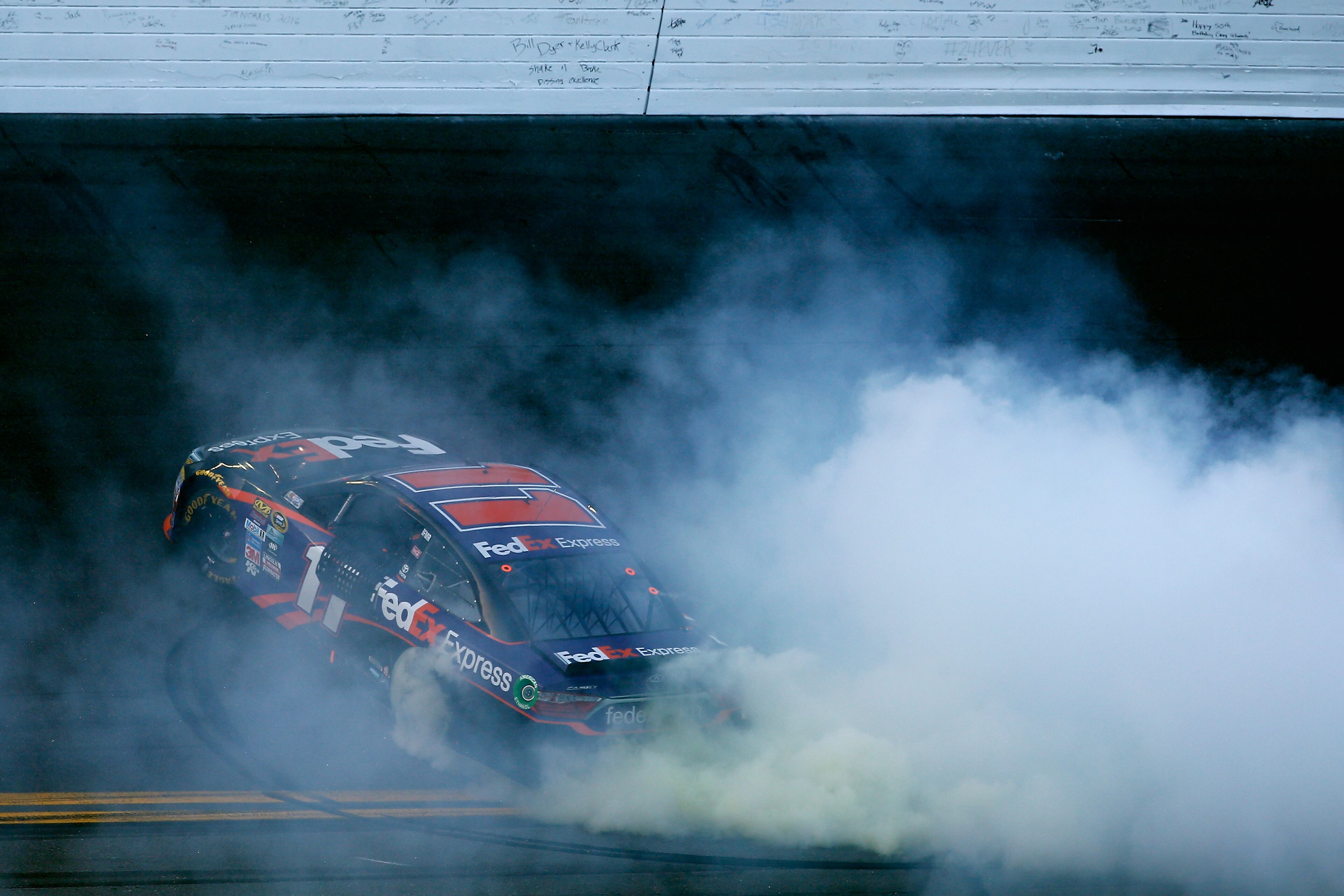 Denny Hamlin, driver of the #11 FedEx Express Toyota, celebrates with a burnout after winning the NASCAR Sprint Cup Series DAYTONA 500 at Daytona International Speedway on February 21, 2016 in Daytona Beach, Florida. (Photo by Jonathan Ferrey/Getty Images)