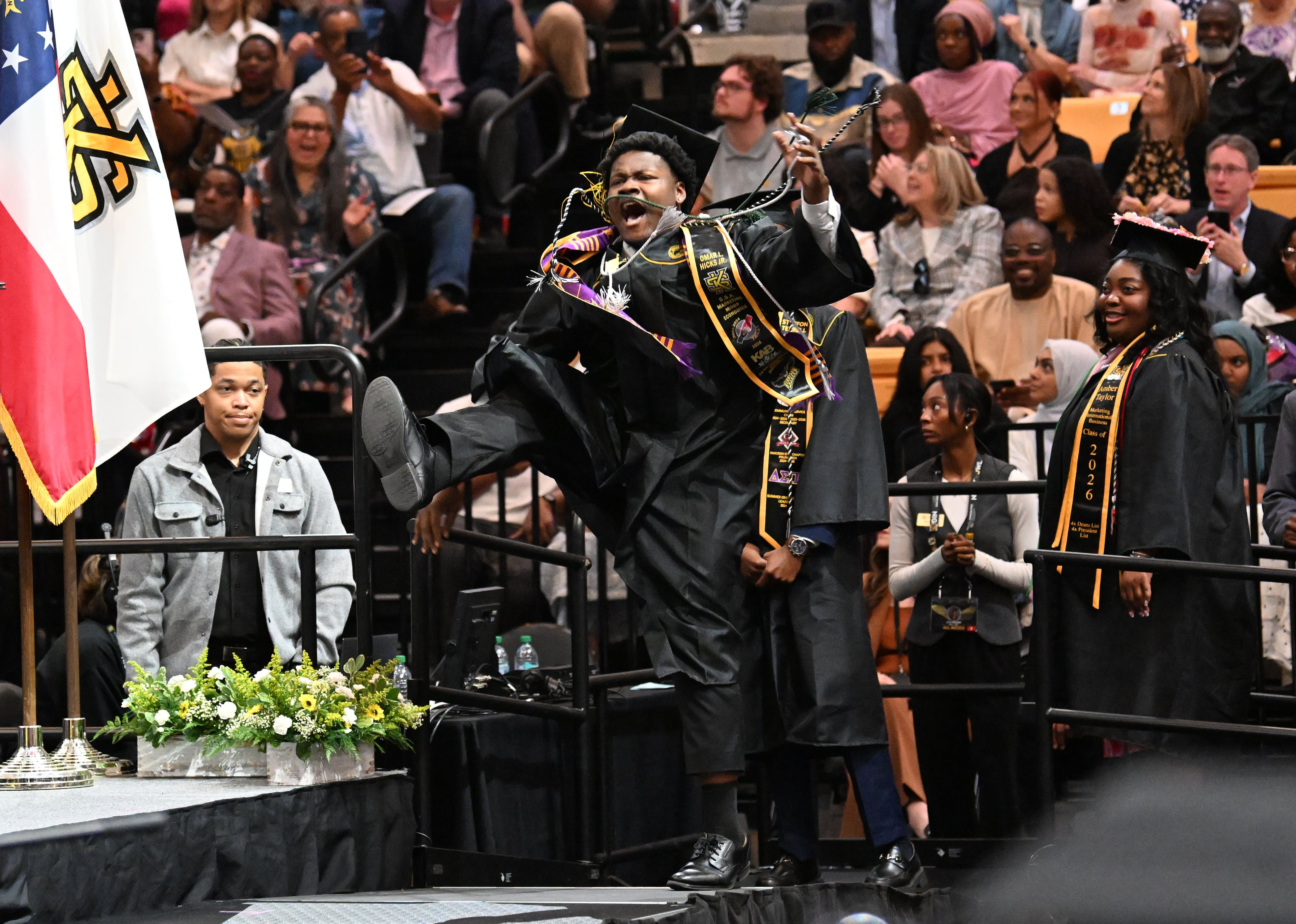 KSU graduate Omar Hicks Jr. celebrates as he walks onto the stage to receive his diploma. (Hyosub Shin/AJC)