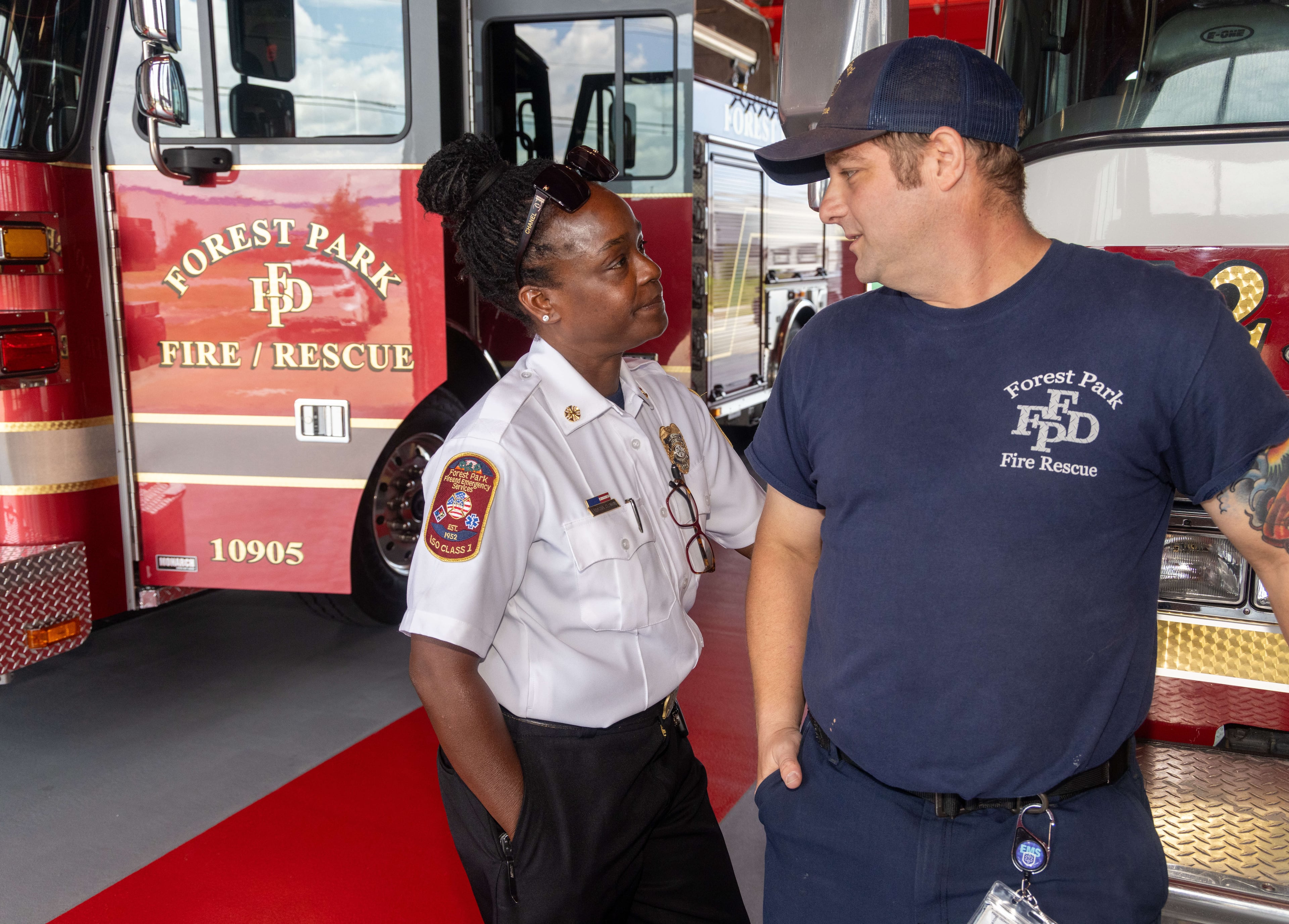Fire Chief Latosha Clemonschats with FAO Jonathan Daniel at the Forest Park Public Safety building. Clemons' Camp Believe provides girls with a firsthand look at what a firefighting job entails. (Phil Skinner for the AJC)