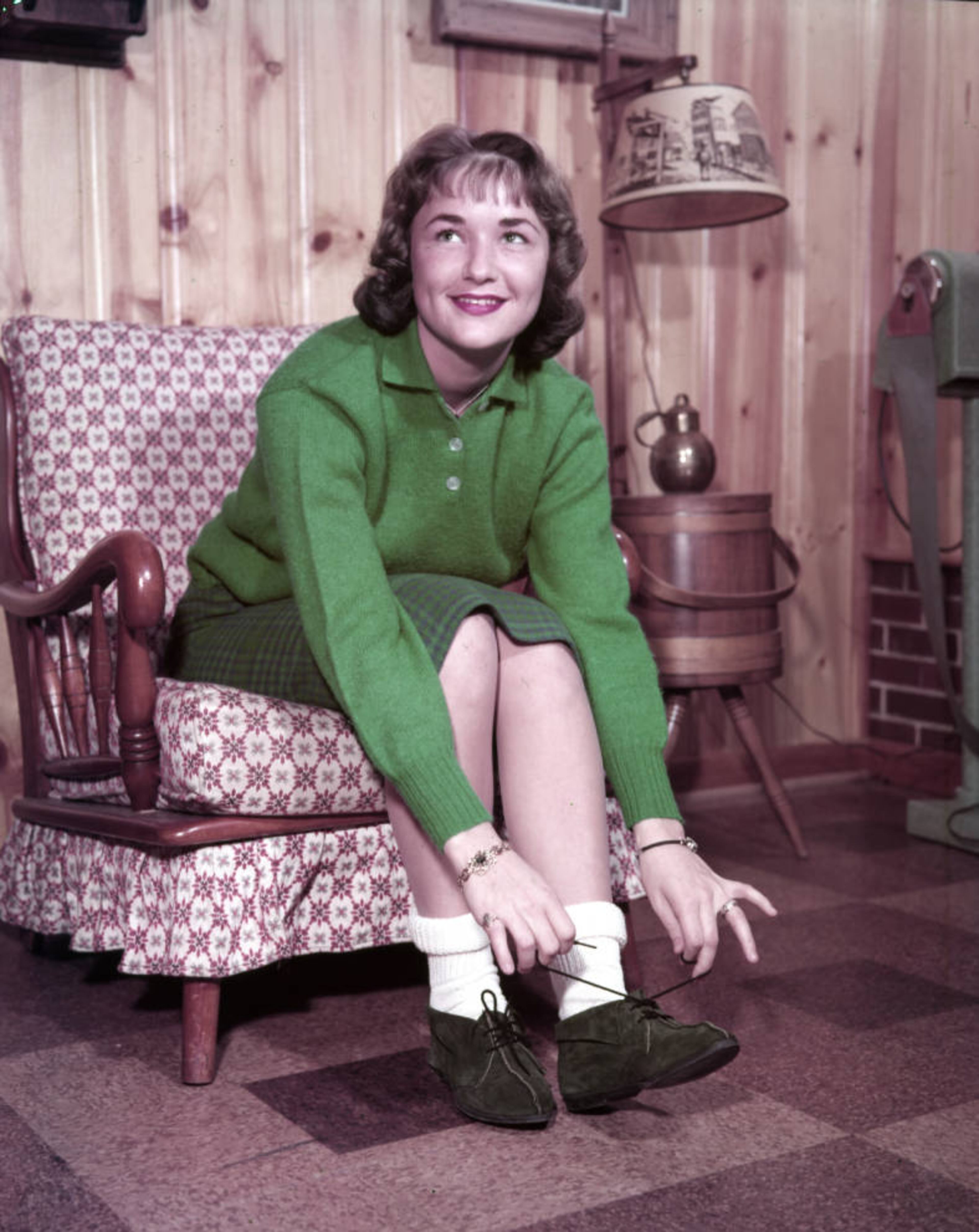 From the original caption info in 1959: "Judy Godfrey laces up a pair of 'boot' shoes. That's a friendship ring on Judy's left hand."