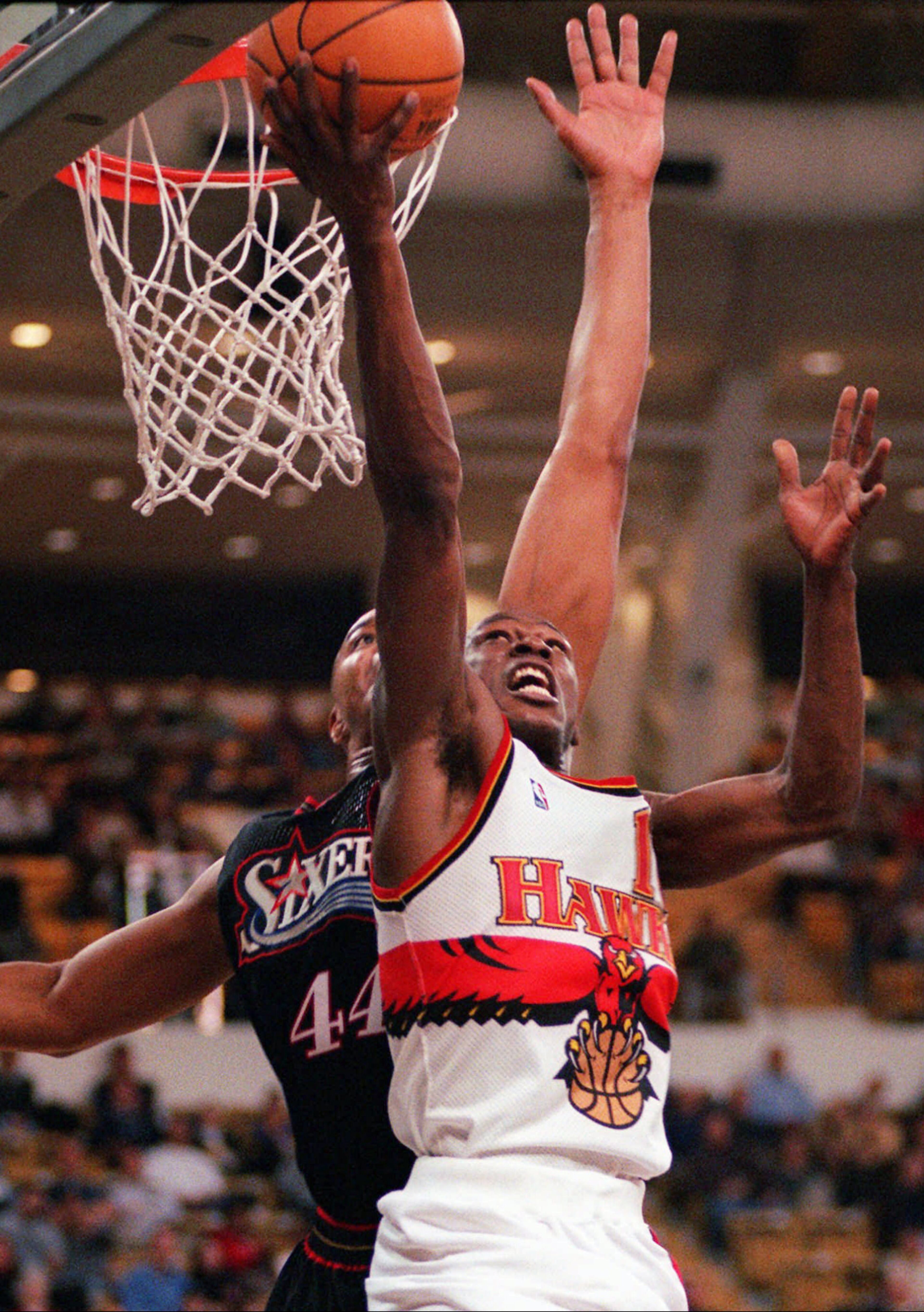 Atlanta Hawks guard Mookie Blaylock tries a reverse layup under pressure from Philadelphia 76ers forward Derrick Coleman during the first half in Atlanta on Jan. 29, 1998. (AP Photo/Alan Mothner)