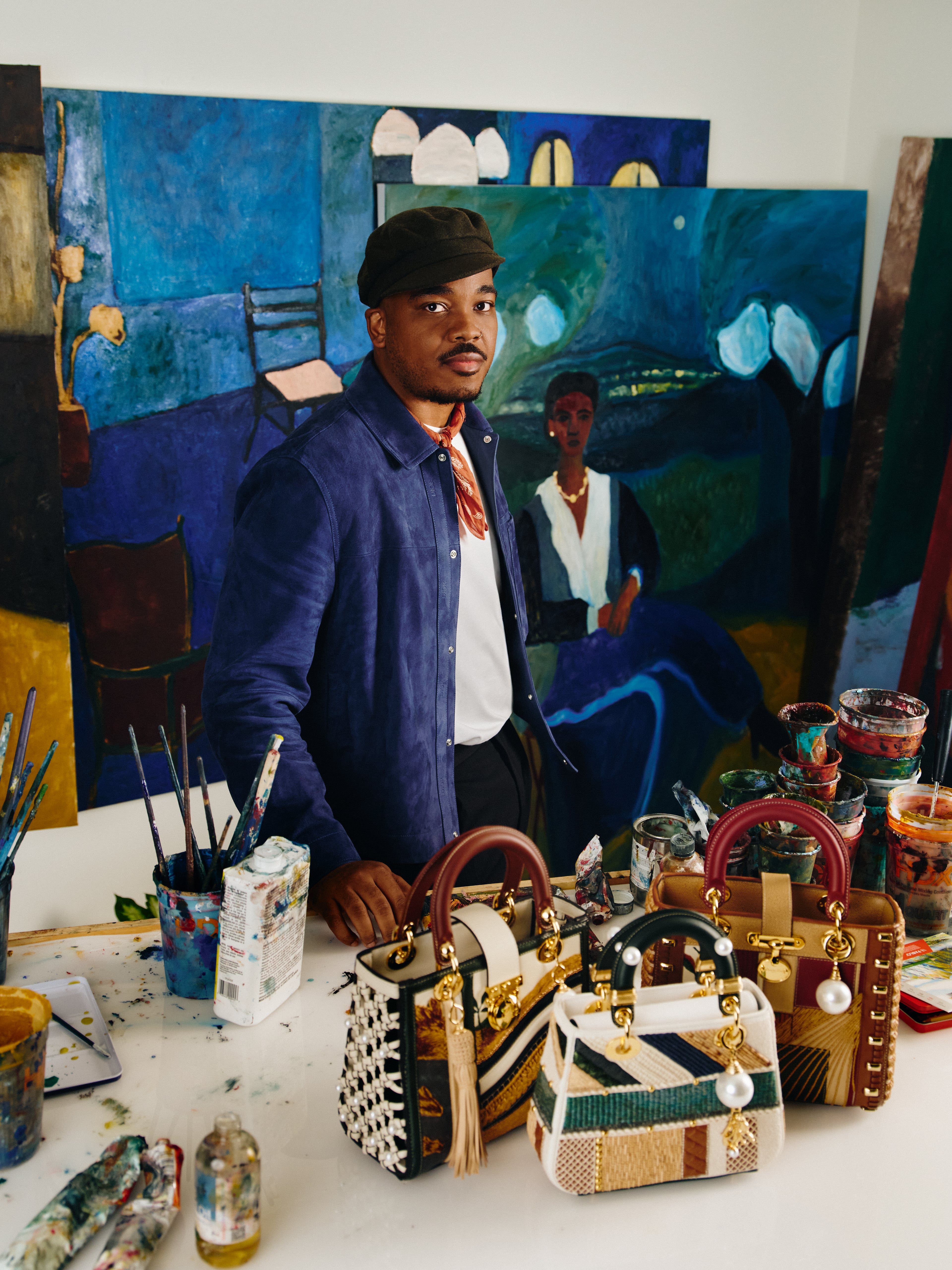 Patrick Eugène stands behind three handbags he designed as a 2025 participant in the 10th annual Dior Lady Art project. Only 10 international artists, including just two American artists, were selected to reimagine the Lady Dior handbag as contemporary art. (Courtesy of Heather Sten)