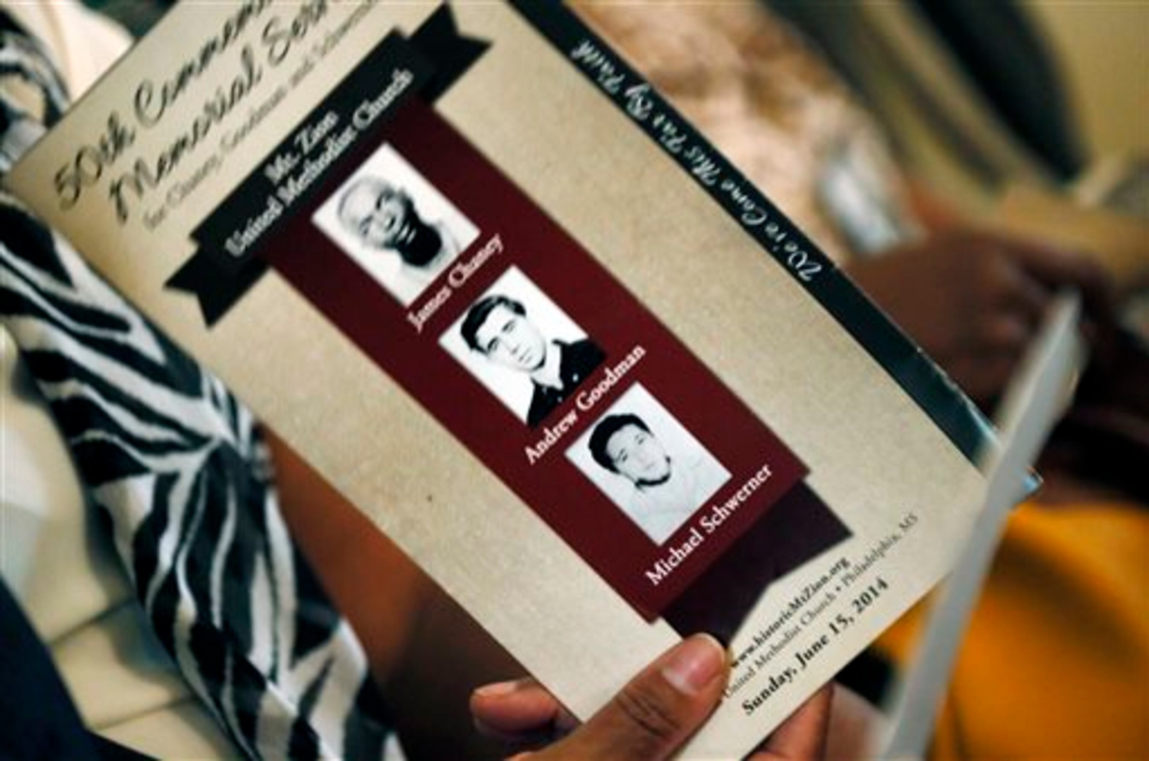 A program is used as a fan at the Mt. Zion United Methodist Church in Philadelphia, Miss., Sunday, June 15, 2014, during a commemorative service for three civil rights workers killed in Neshoba County for their voter registration work among blacks in then segregationist Mississippi. (AP Photo/Rogelio V. Solis)