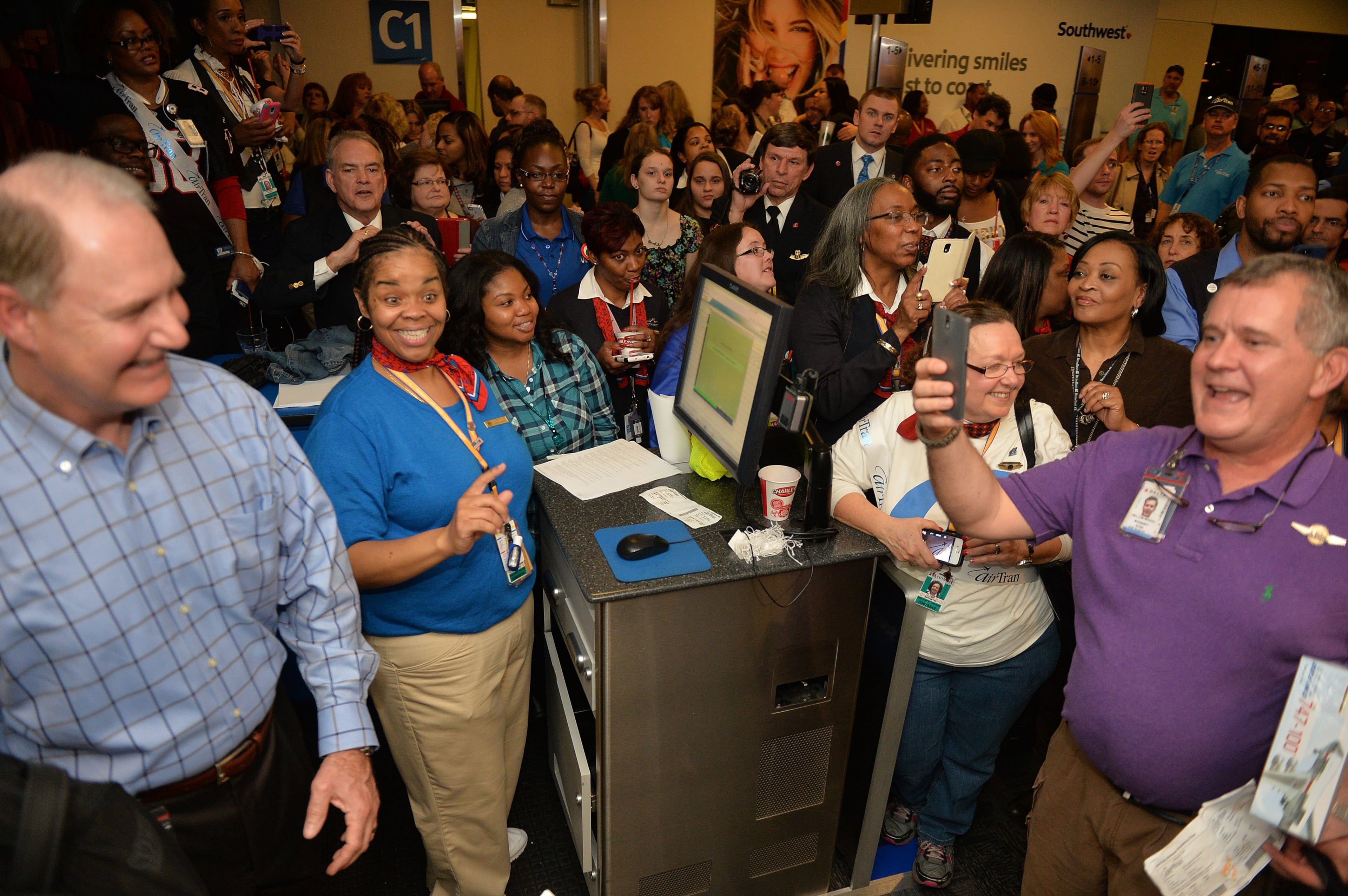 Southwest CEO Gary Kelly (left) and ops agent Netta Morgan greet fliers as they board. Hundreds of Southwest Airlines and former AirTran Airways employees gathered at Concourse C, gates 1, 2 and 3 to celebrate the departure of AirTran’s final flight to Tampa FL, at Hartsfield-Jackson International Airport, Sunday, December 28, 2014. Southwest CEO Gary Kelly and executives Bob Jordan and Jack Smith gave remarks during the program. The full flight was waved off by employees that gathered on the tarmac as crash trucks from Atlanta Fire Rescue gave a final water cannon salute as the plane departed. KENT D. JOHNSON/KDJOHNSON@AJC.COM