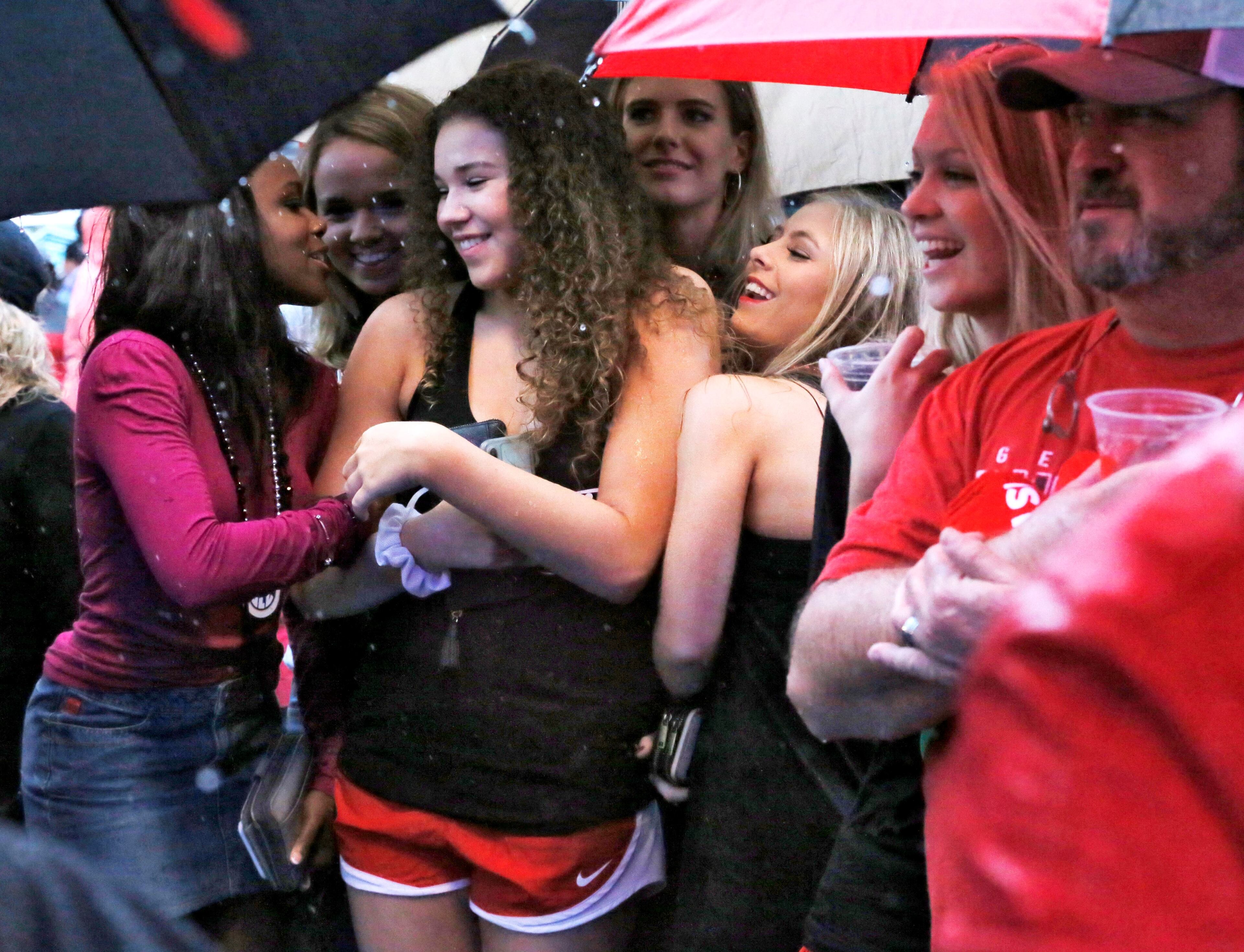 12/31/18 - New Orleans - Georgia fans huddle under umbrellas as heavy rain came in just before the start of the rally. Georgia fans braved heavy rain to cheer on their team at an afternoon pep rally at Allstate Fan Fest in the French Quarter of New Orleans. Georgia plays Texas in the Sugar Bowl on Jan 1st. Bob Andres / bandres@ajc.com