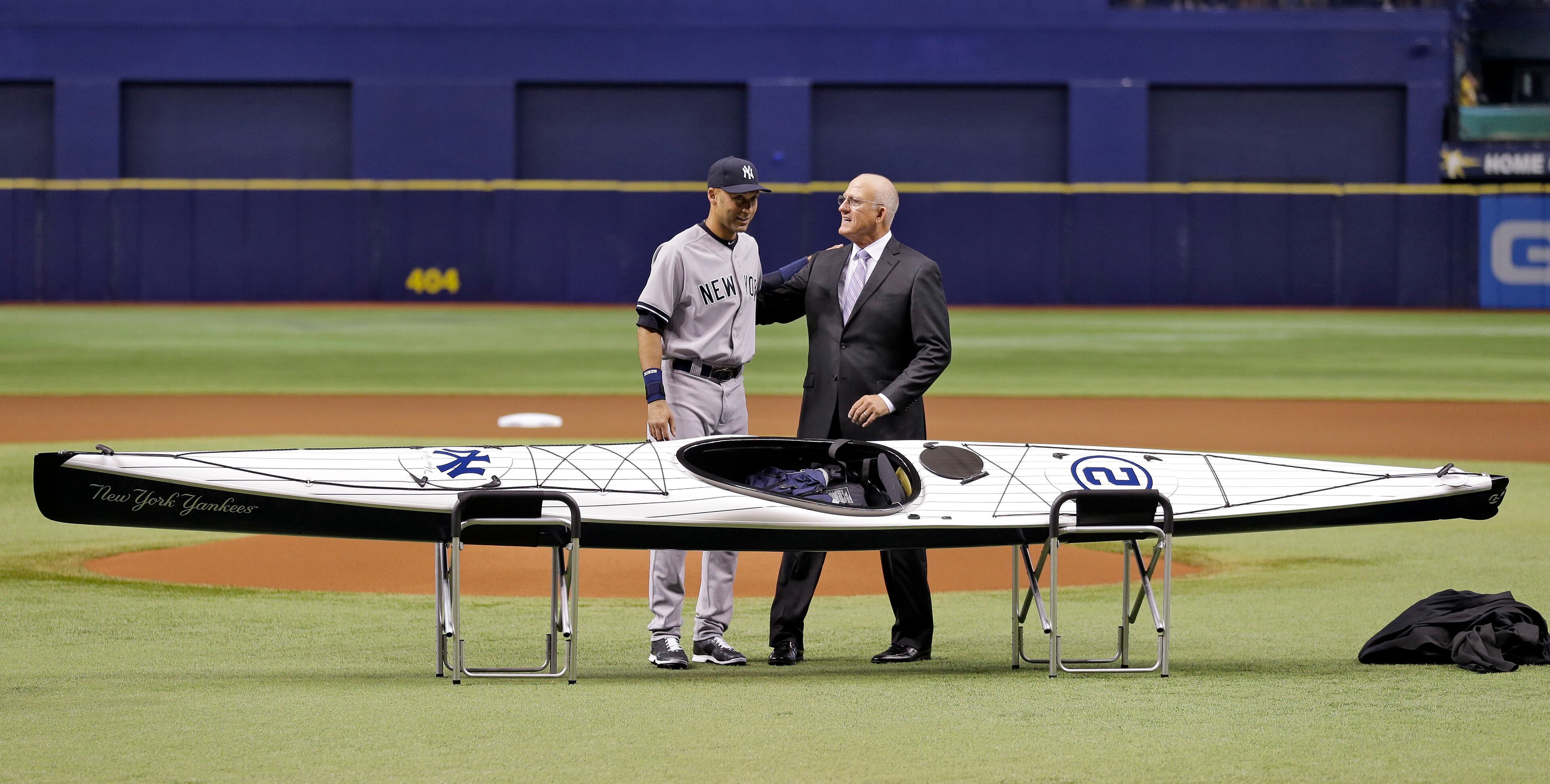 New York Yankees' Derek Jeter, left, hugs Mitch Lukevics, Tampa Bay Rays Director of Minor League Operations after being presented with a kayak by the Rays as a going away gift before a baseball game Tuesday, Sept. 16, 2014, in St. Petersburg, Fla. Jeter is retiring at the end of the season. (AP Photo/Chris O'Meara)