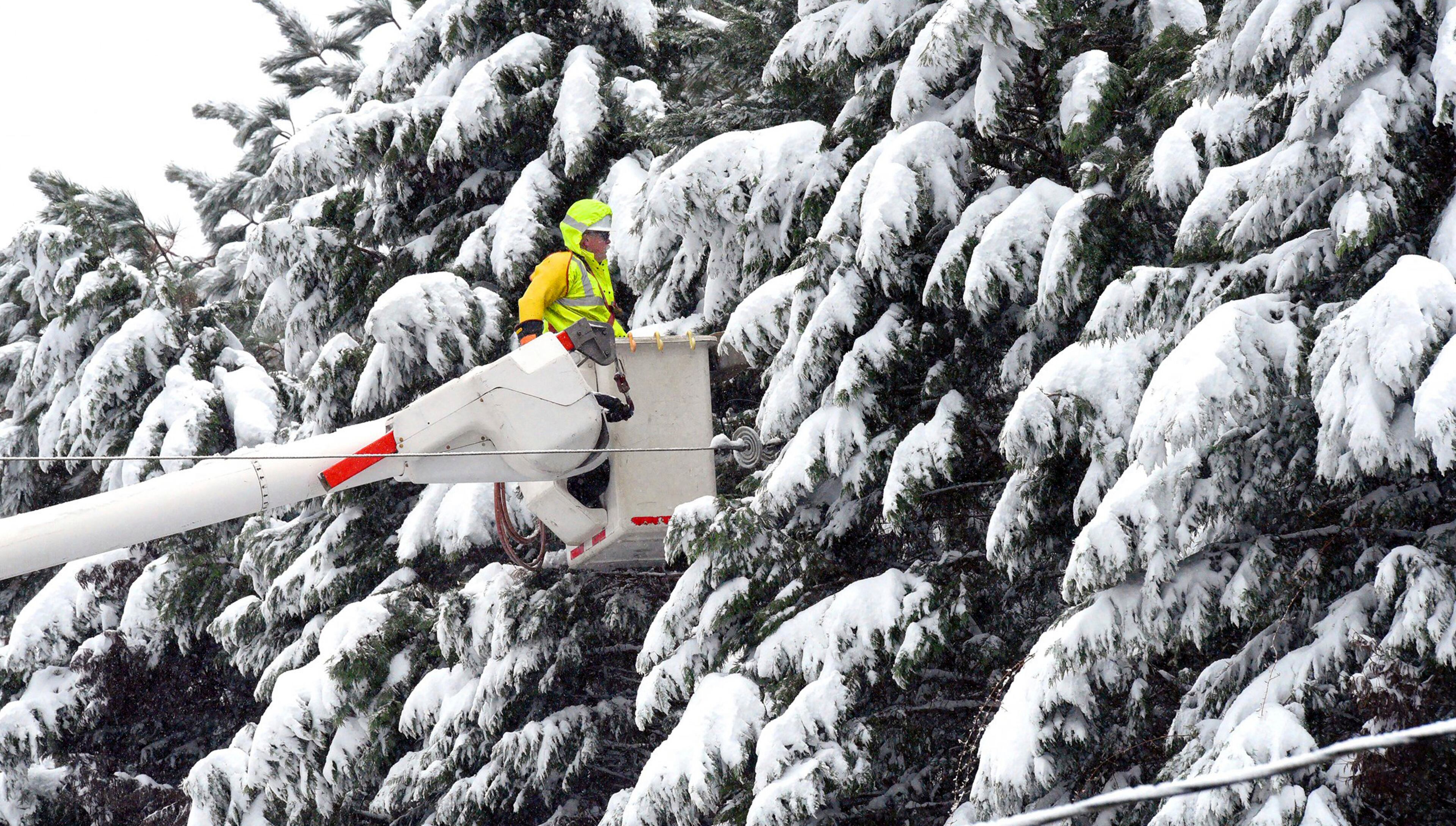 A Duke Energy lineman uses a bucket truck to approach a transformer on Hope Valley Road in Durham, N.C. Sunday, Dec. 9, 2018 as heavy snow blankets the area. Power is out in many areas and local roads are almost impassible as the late fall snowstorm hit North Carolina. (Chuck Liddy/The News & Observer via AP)