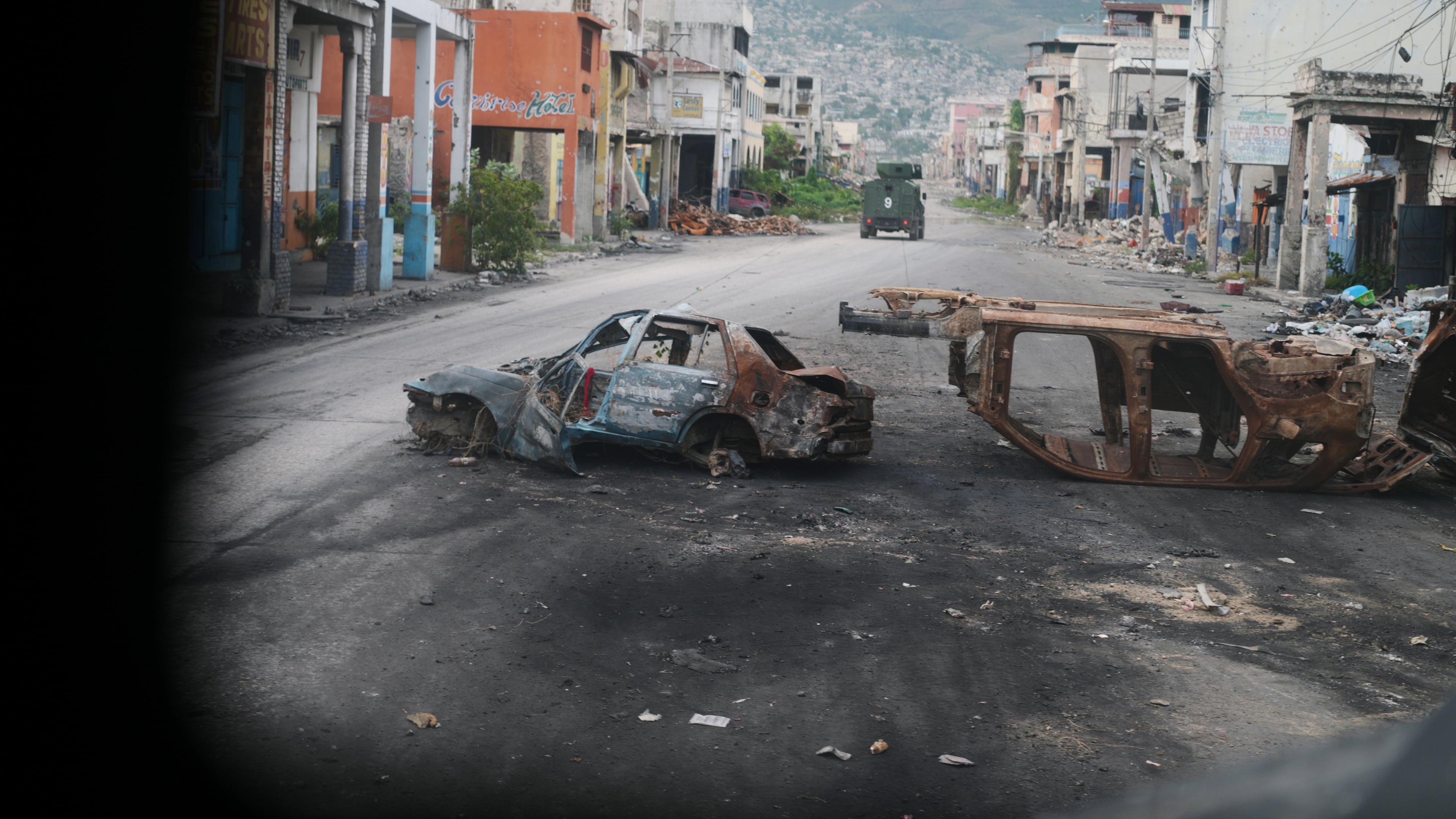 Burned cars block a street, photographed from inside an armored police vehicle patrolling a gang-controlled area in Port-au-Prince, Haiti, Friday, Jan. 16, 2026. (AP Photo/Odelyn Joseph)