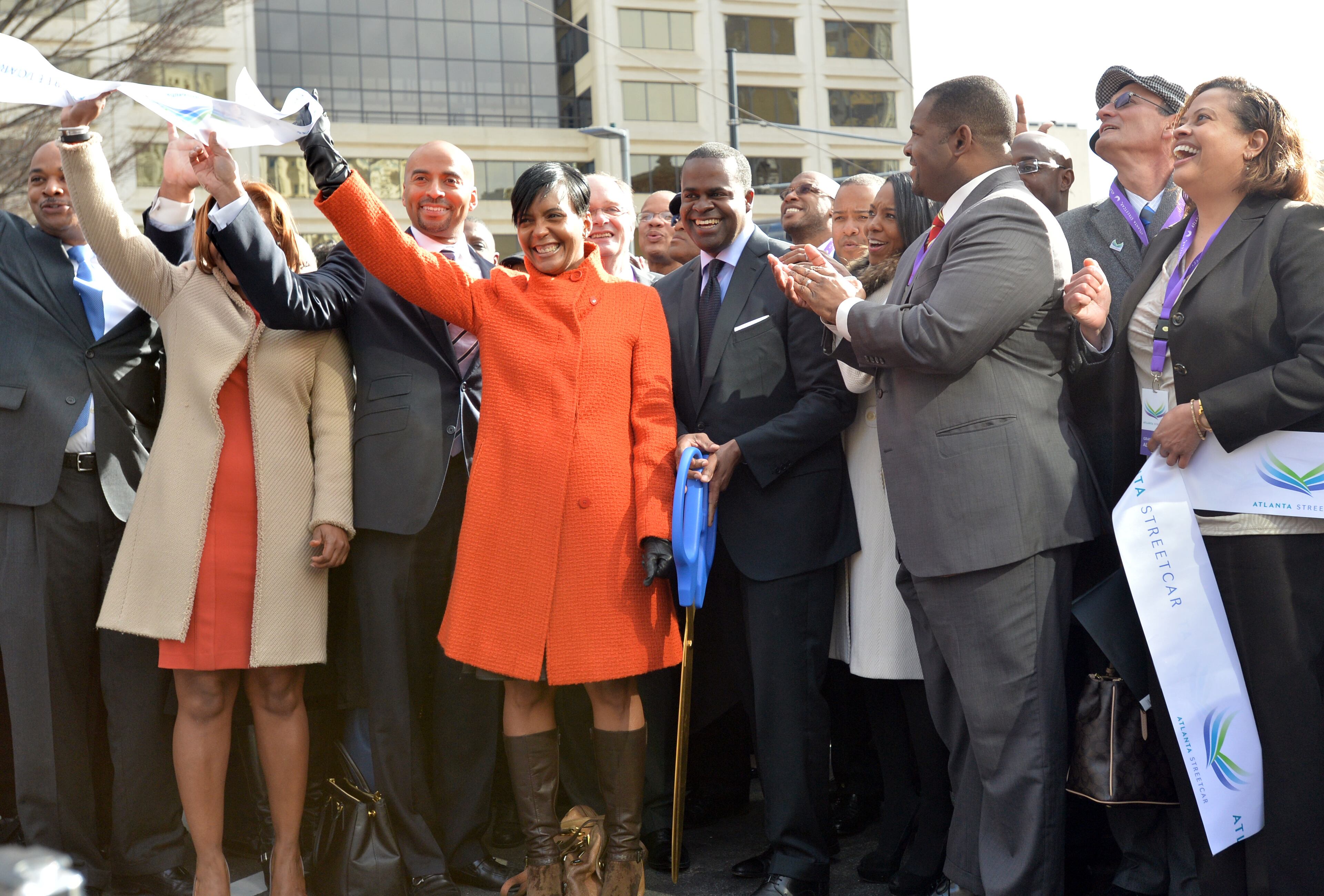 Atlanta Mayor Kasim Reed, center, with big scissors, smiles after he cut the ribbon with other VIP guests during a grand opening ceremony at Woodruff Park on Tuesday, December 30, 2014. HYOSUB SHIN / HSHIN@AJC.COM